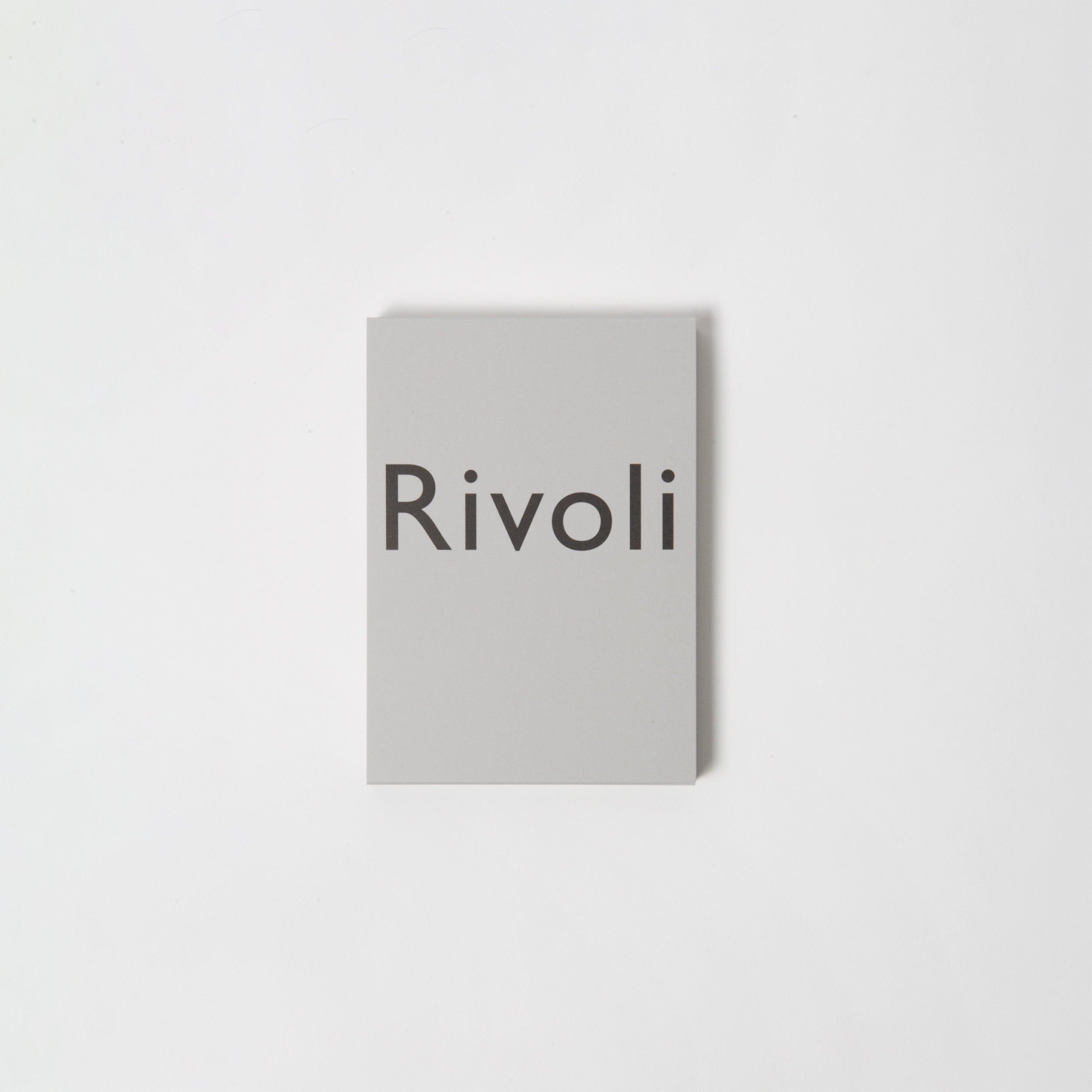 Diese hellgraue Karte von Carta Pura zeigt den Namen „Rivoli“ in elegantem Schwarzdruck, der an hochwertiges Briefpapier erinnert, vor einem makellos weißen Hintergrund.