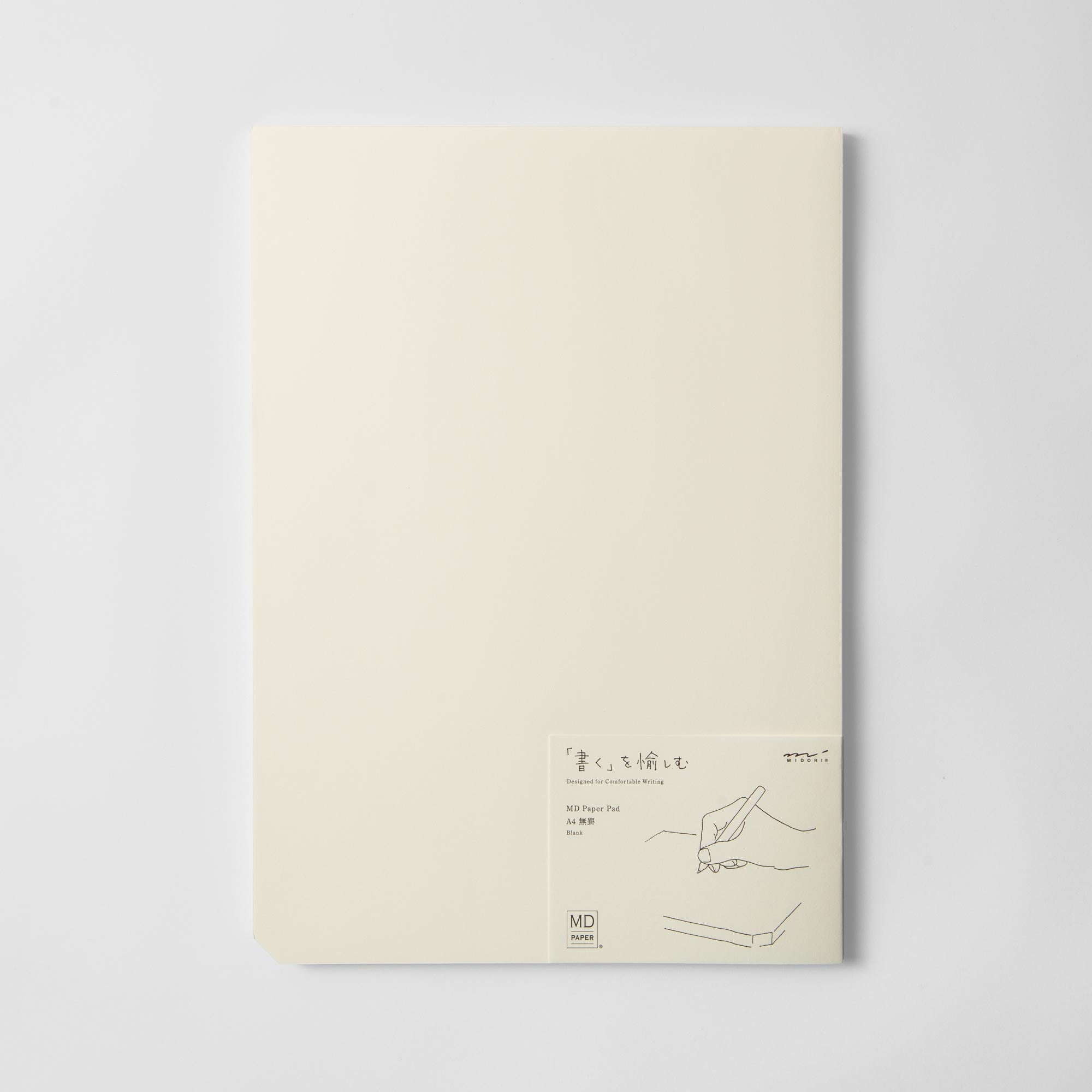 Der Skizzenblock A4 von Midori hat einen cremefarbenen Einband mit einer minimalistischen Strichzeichnung einer Handschrift. Unten rechts ist ein kleines zweisprachiges Etikett mit Produktinformationen angebracht. Ideal zum Aufschreiben von Notizen oder zum Aufzeichnen schneller Skizzen.