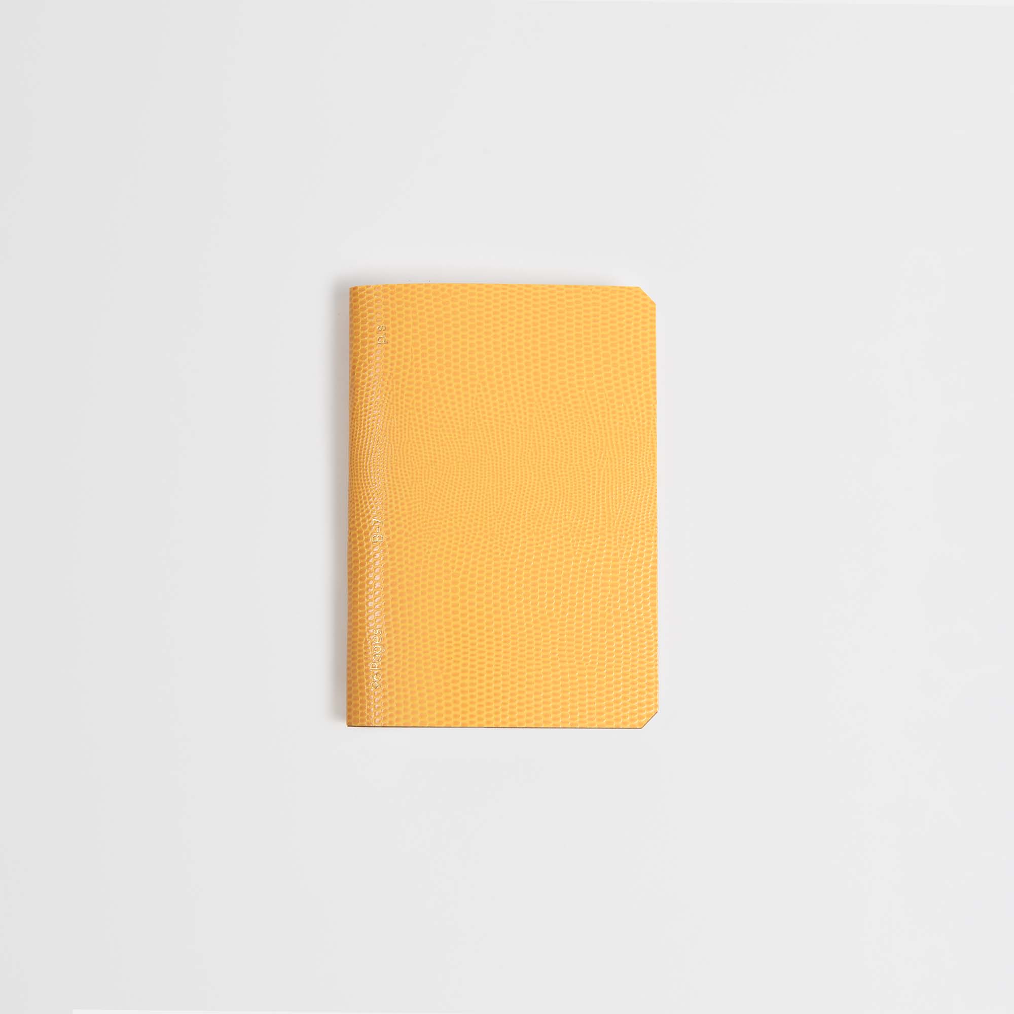Das B96 Mellow Yellow Softcover-Notizbuch von paperlux.store mit kleinem Format, gelbem Farbton, strukturiertem Einband und abgerundeten Ecken ist auf einem schlichten weißen Hintergrund zentriert.