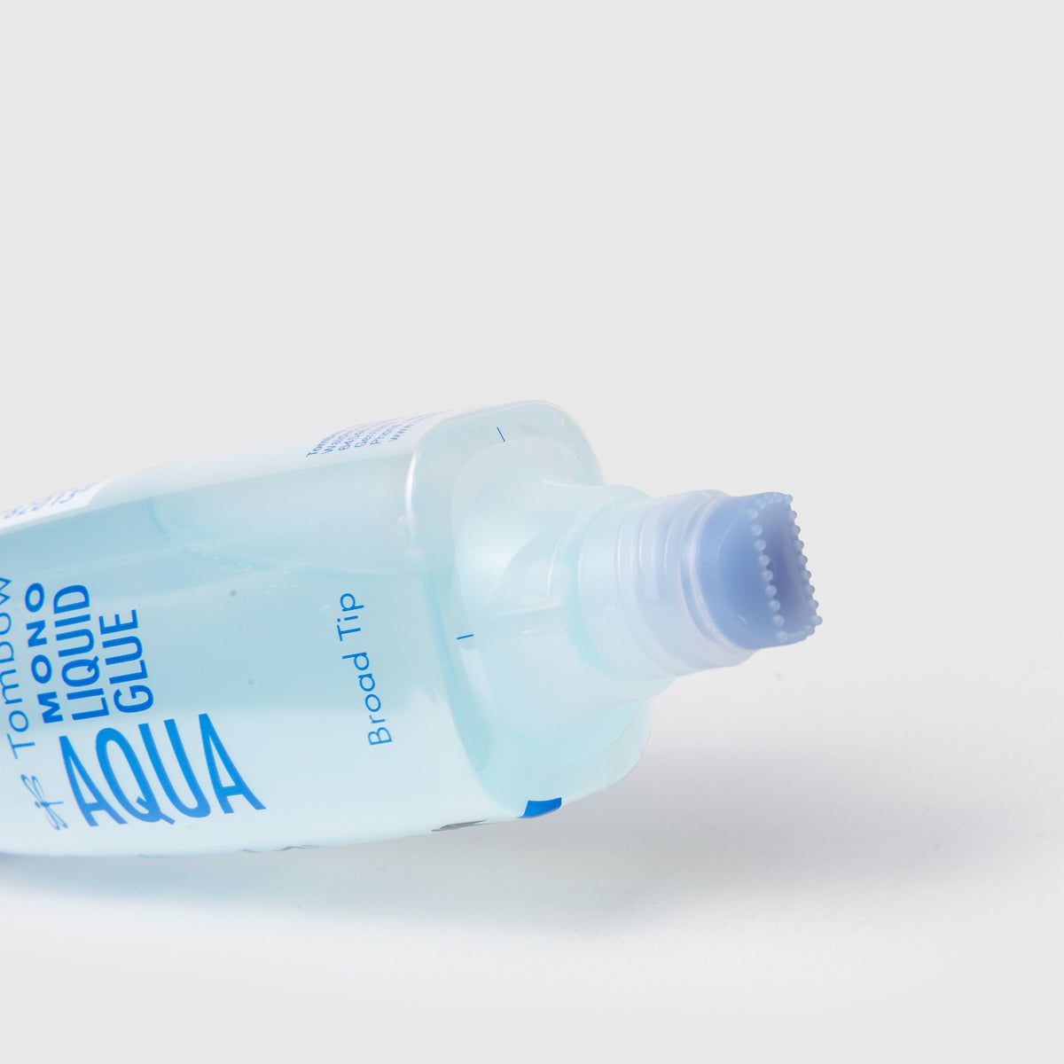 Tombow MONO Aqua Flüssigkleber in einer durchsichtigen Plastikflasche mit einer breiten, geriffelten Auftragsspitze.