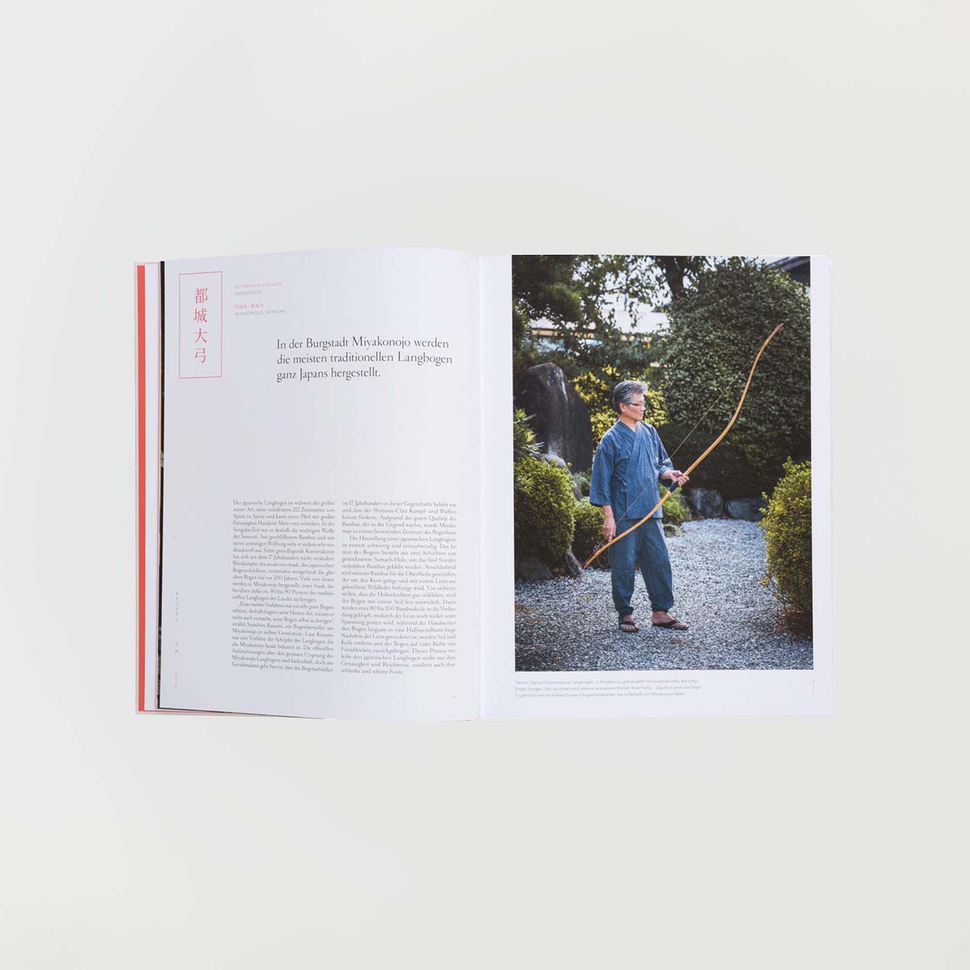 Eine aufgeschlagene Zeitschrift zeigt links einen Artikel und rechts ein Foto. Darin ist eine Person mit einem langen Holzbogen zu sehen, die „Das Streben nach Vollkommenheit“ vom Gestalten Verlag verkörpert. Sie ist blau gekleidet und steht wunderschön auf einem Kiesweg, umgeben von üppigem Grün in einem Garten.