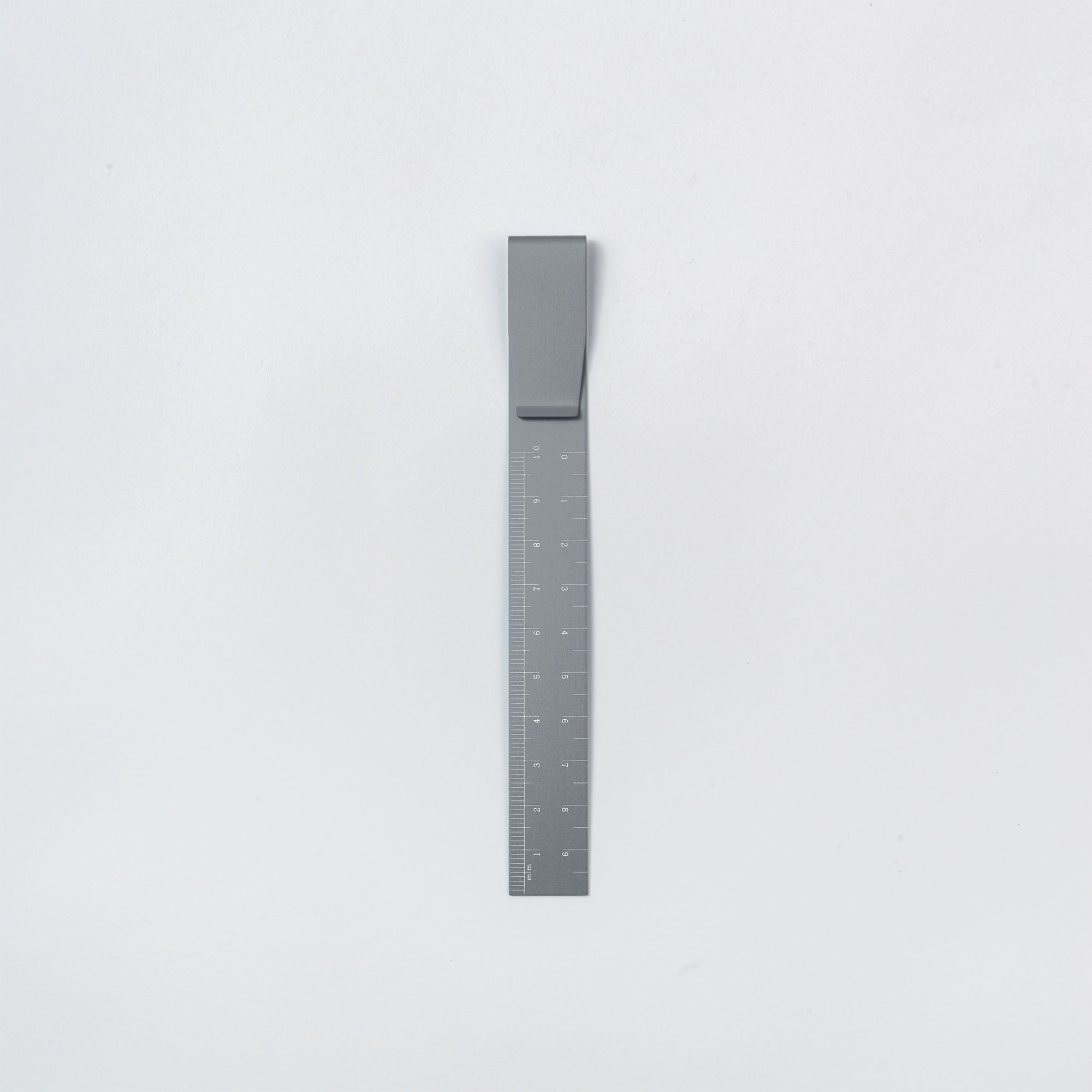 Das Clip Ruler - das Lineal To Go von Hightide, ein minimalistisches Metall-Faltlineal mit Scharnier zum einfachen Zusammenklappen, verfügt über Maßangaben in Zentimetern und Zoll, perfekt für Ihr Bullet Journal. Es liegt auf einem schlichten weißen Hintergrund.