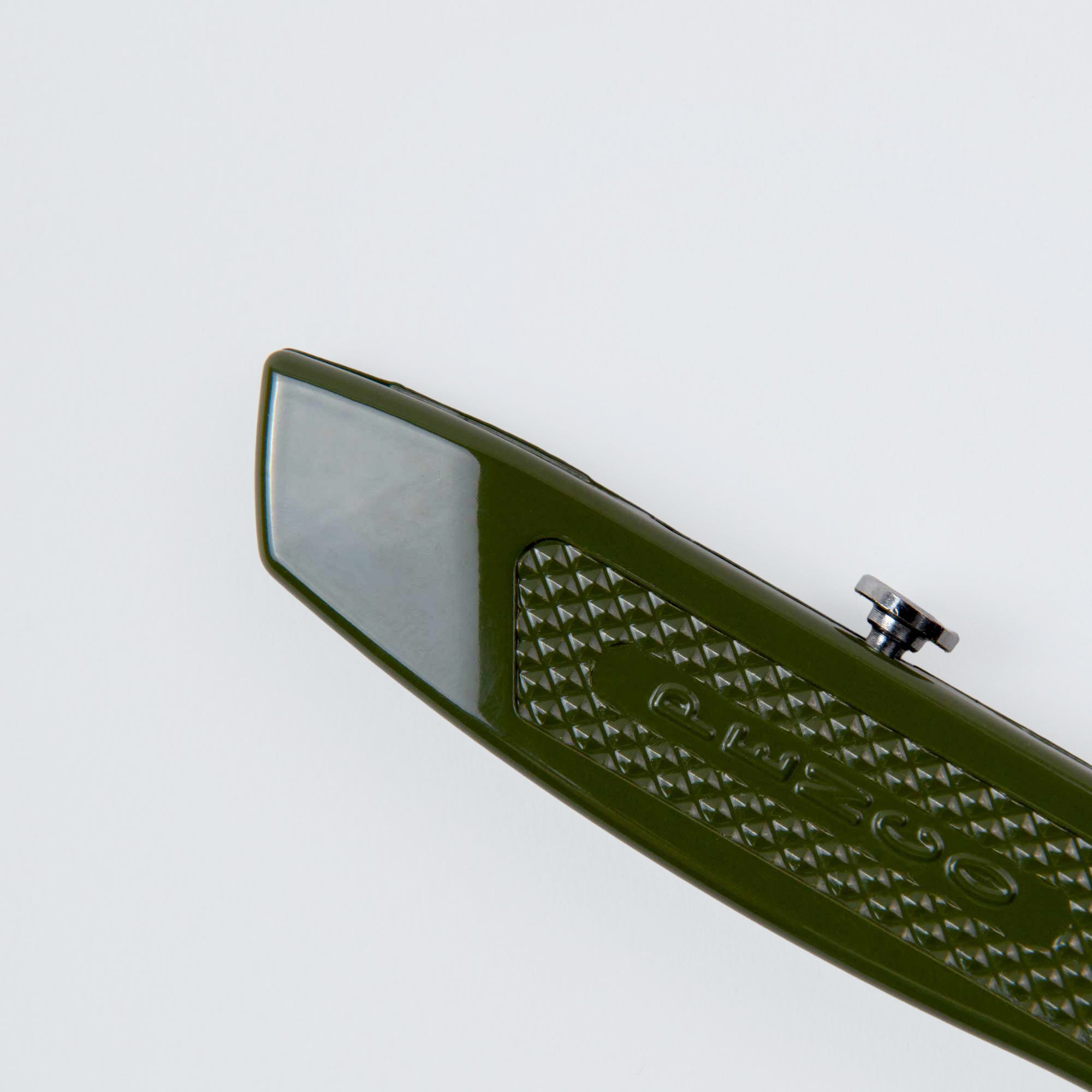 Eine Nahaufnahme eines grünen Penco Allzweckmessers, auch bekannt als Cutter an der Kette, mit einem Metallknopf und dem Schriftzug "oltzoo", fotografiert auf weißem Hintergrund.