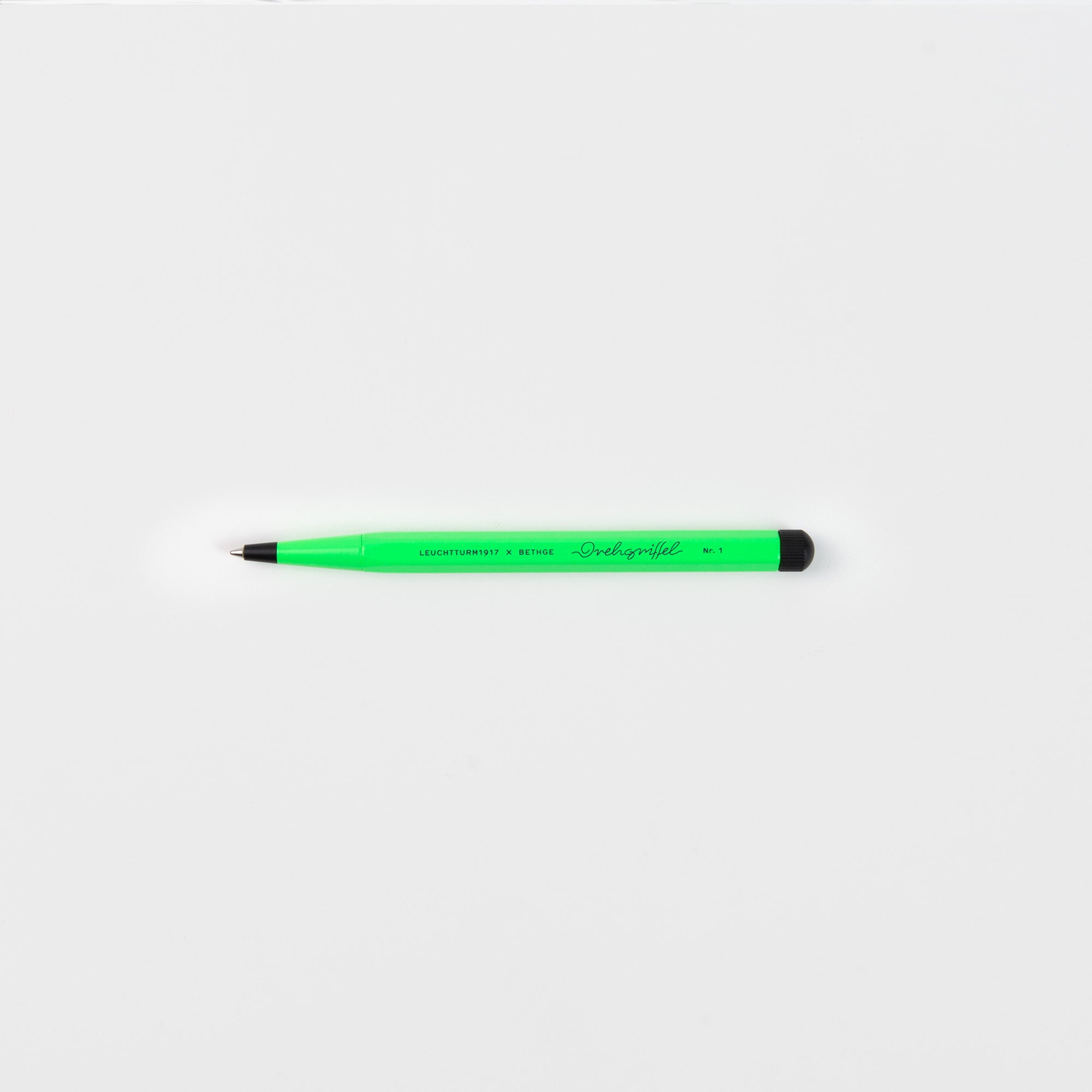 Ein Leuchtturm 1917 Drehgriffel No. 1 Luminous Edition Kugelschreiber in grün mit schwarzer Spitze und Endkappe ist auf einem schlichten weißen Hintergrund zentriert.