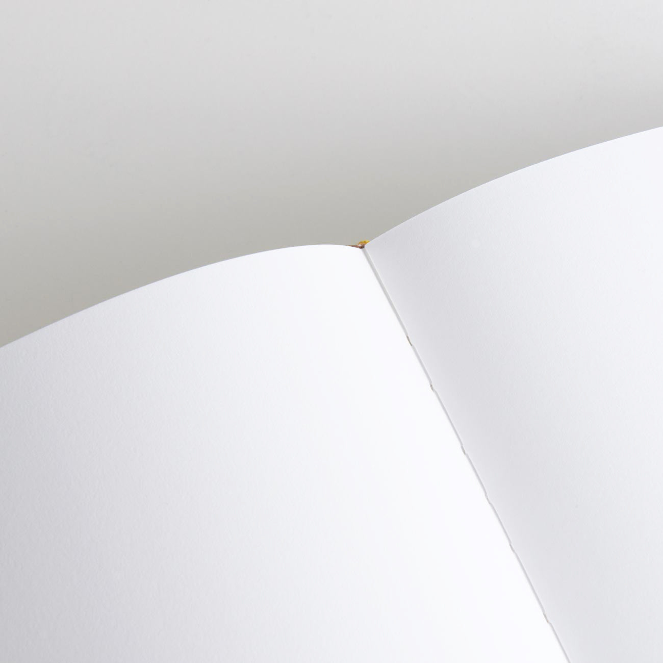 Nahaufnahme eines geöffneten Gästebuchs – „Welcome to our crib“ von We are Bookbinders. Die glatte Oberfläche und die sauberen Seiten in der Mittelfalte werden hervorgehoben. Das in Hamburg gefertigte Buch ist auf einem schlichten, hellen Hintergrund platziert.