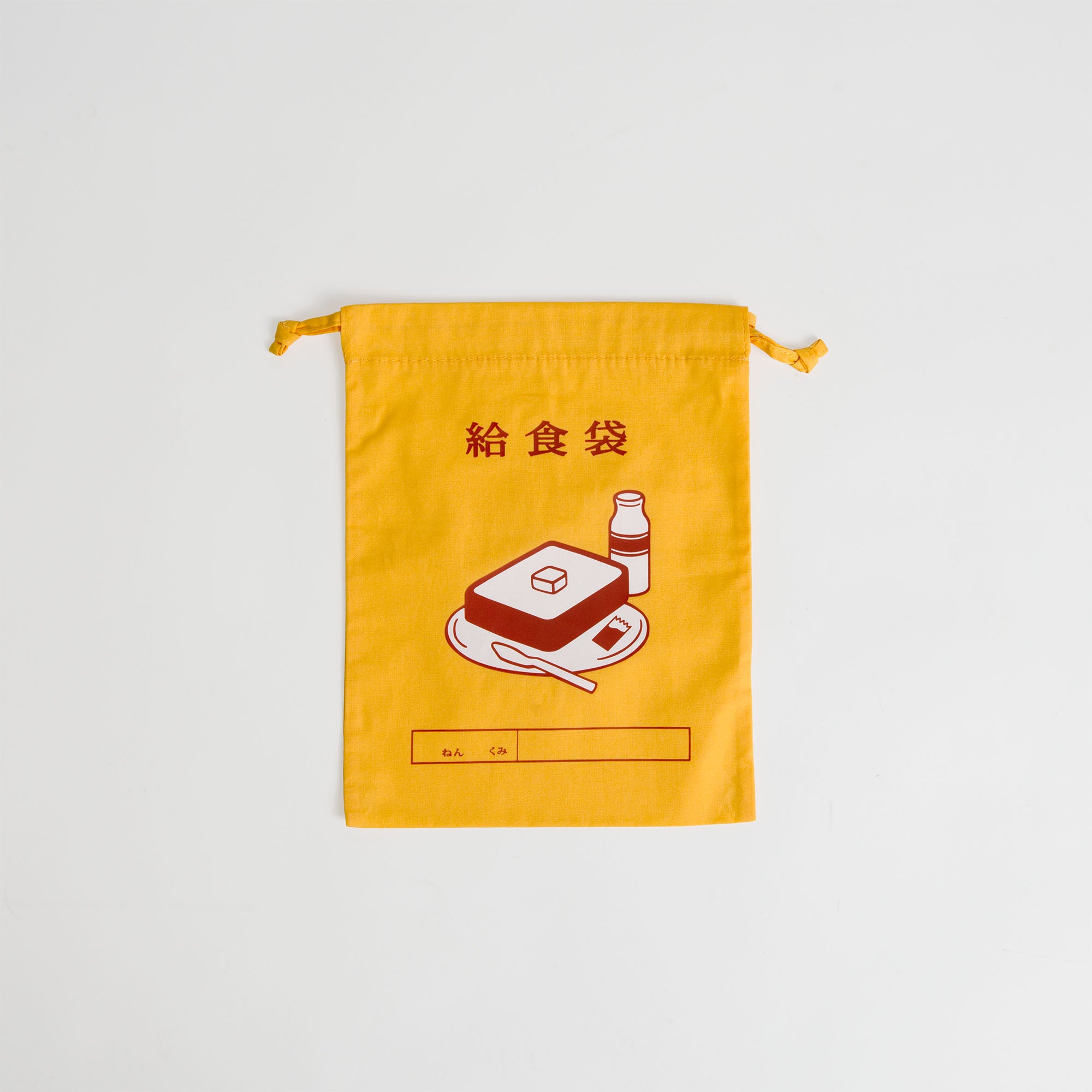 Der gelbe Hightide Beutel mit Kordelzug Medium ist mit japanischem Text und einer Illustration von Brot und einer Getränkeflasche sowie einem Blankoetikett für Ihren Namen versehen. Die Tasche ist flach auf einer weißen Oberfläche abgebildet.