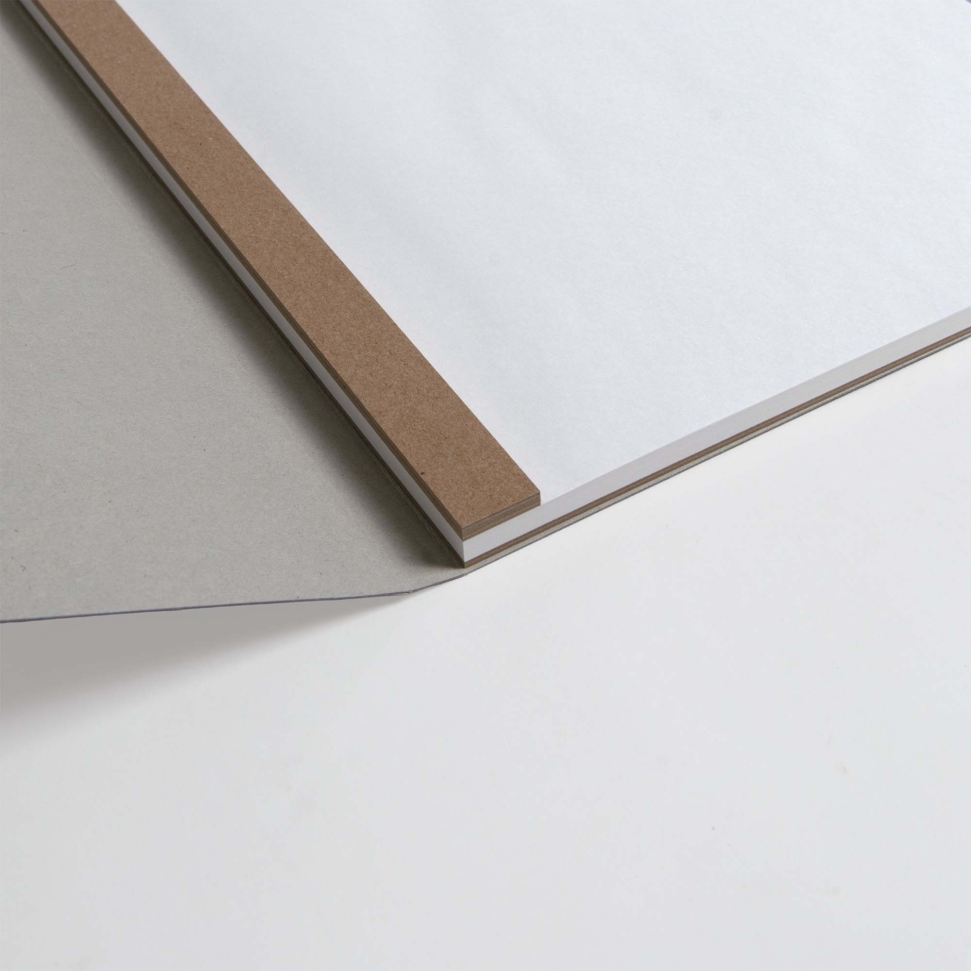 Der ITO Bindery Drawing Pad White von ITO Bindery, mit dickem japanischem Papier und Spiralbindung, verfügt über einen braunen Streifeneinband und eine graue Papprückwand, die elegant auf einer weißen Oberfläche präsentiert wird.