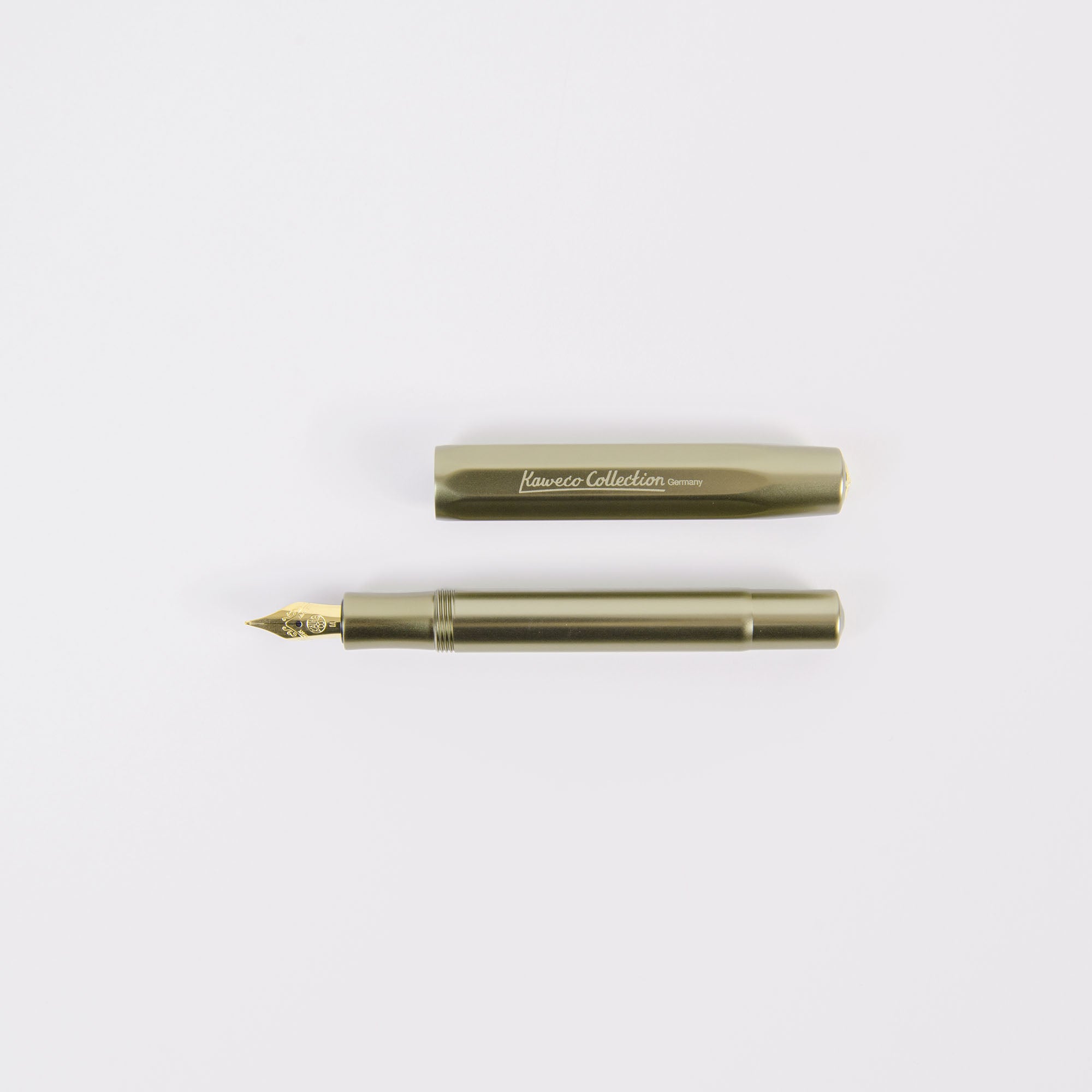 Der KAWECO Füllhalter - limitierte Edition Olivine besticht durch sein elegantes Metalldesign in Silber mit der Aufschrift „Kaweco Collection Germany“. Die passende Kappe liegt neben dem geöffneten Stift, gibt den Blick auf die Feder frei und hebt sich vom weißen Hintergrund ab.