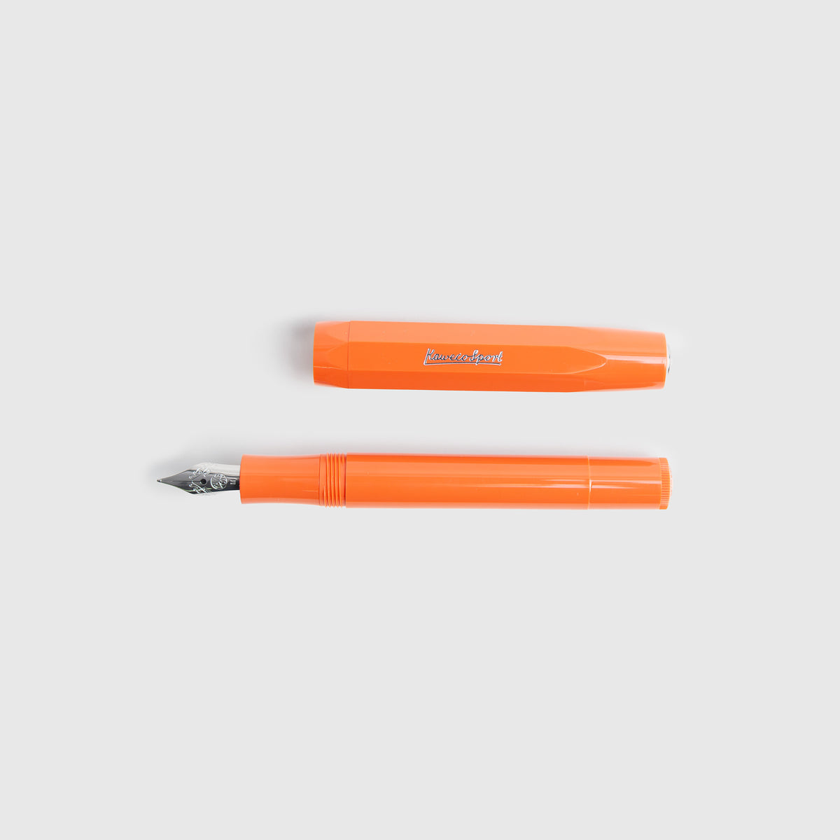 Ein Kaweco Skyline Sport – Füllhalter von Kaweco in Orange mit silberner Feder wird zusammen mit der dazu passenden Kappe auf einem hellgrauen Hintergrund abgebildet.