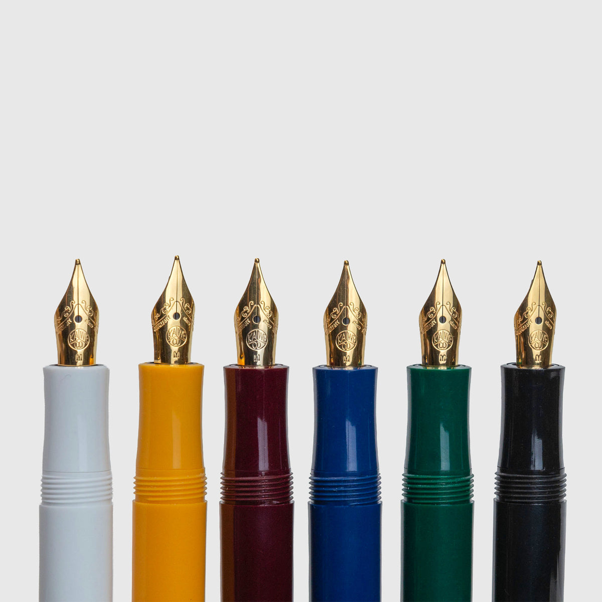 Sechs Kaweco Classic Sport-Füllfederhalter mit goldfarbenen Federn, aufgereiht in den Farben Weiß, Gelb, Burgunderrot, Blau, Grün und Schwarz.