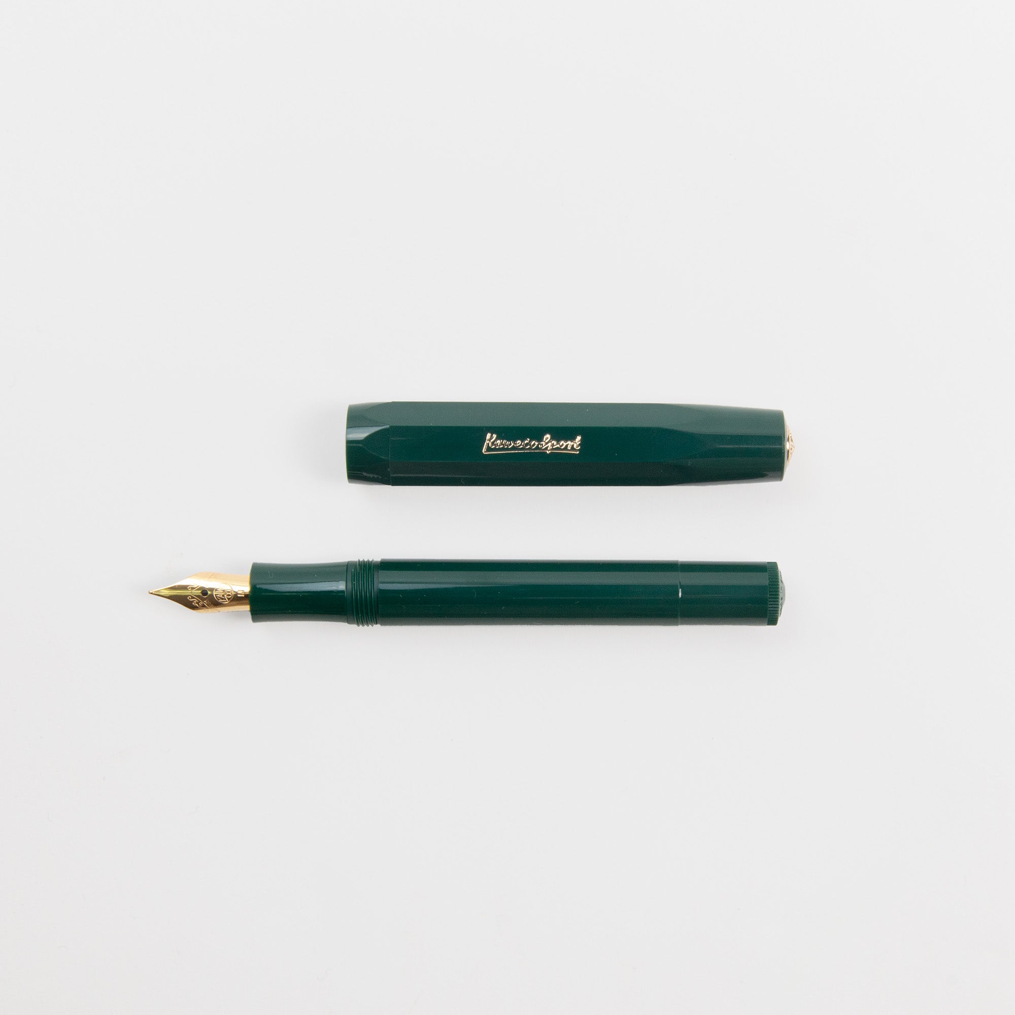 Der dunkelgrüne Kaweco Classic Sport - Füllhalter von Kaweco mit Goldfeder und passender Kappe mit goldenem Schriftzug ruht auf einem weißen Hintergrund.
