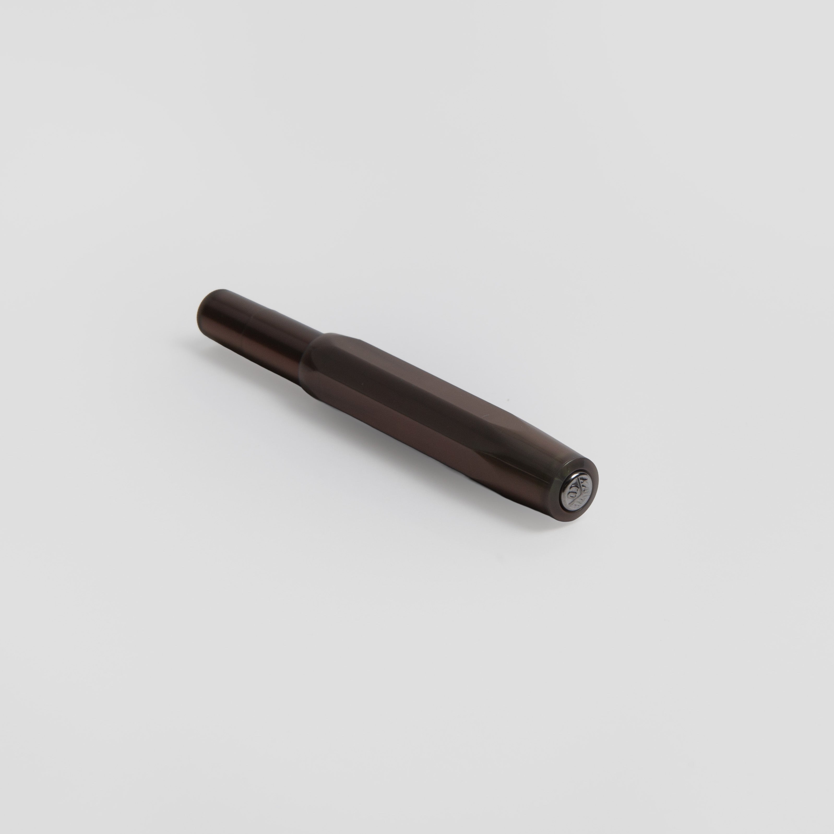 Der Kaweco Lunar Sport - Kugelschreiber, ein dunkler Kaweco Kugelschreiber mit sechseckigem Schaft und dezentem Perleffekt, ruht diagonal auf einer schlichten weißen Fläche.