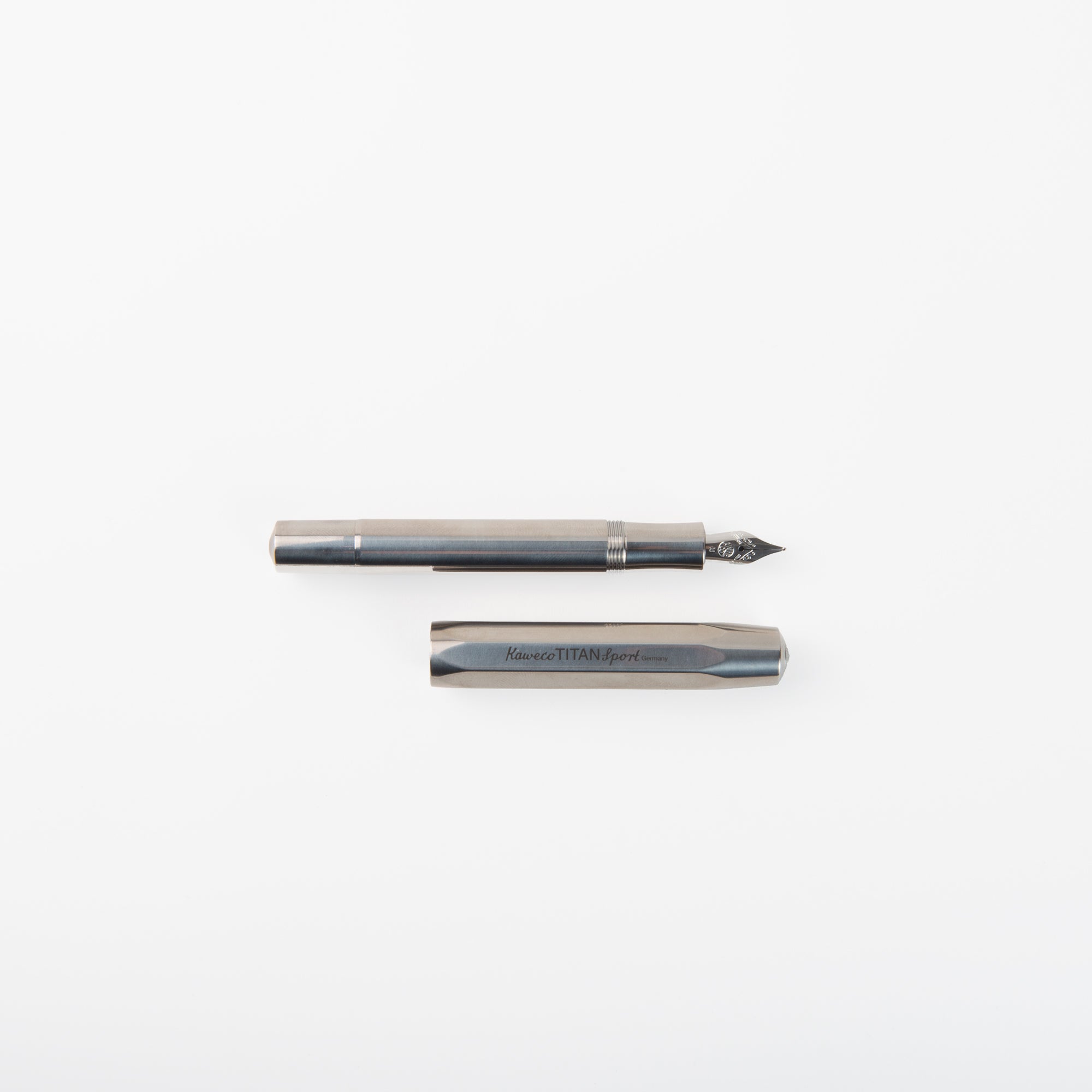 Ein Kaweco Sport Titan - Füllhalter von Kaweco ist mit abgenommener Kappe unter dem Füllfederhalter auf weißem Hintergrund abgebildet.