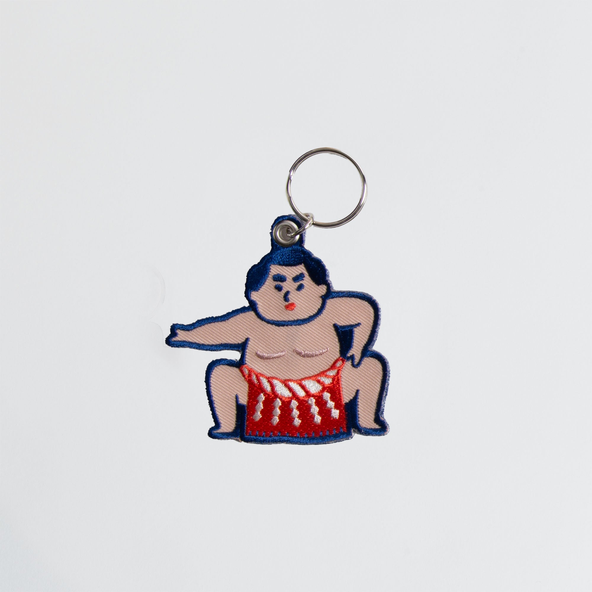 Der Hightide Stitch Work Keychain - Kamera, Daruma & Glückskatze von Hightide zeigt farbenfrohe Stickereien und ist ein originelles Geschenk im Japan-Stil auf weißem Hintergrund.