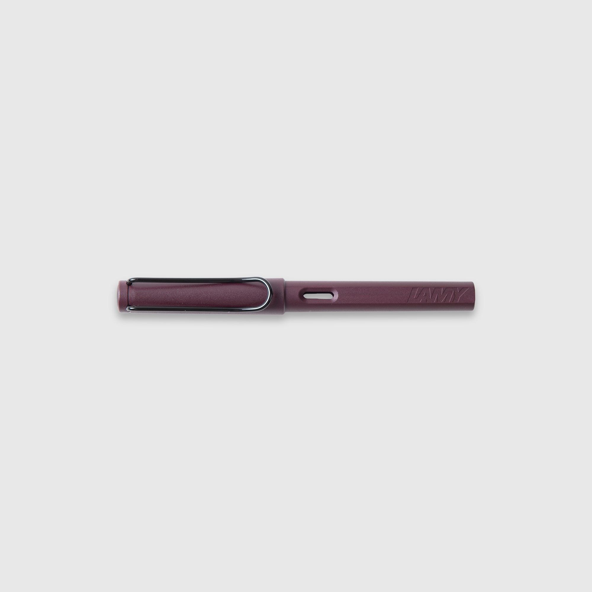 Ein kastanienbrauner LAMY safari Füllhalter von Lamy mit silbernem Clip und Edelstahlfeder, horizontal liegend auf einfarbig hellgrauem Hintergrund.
