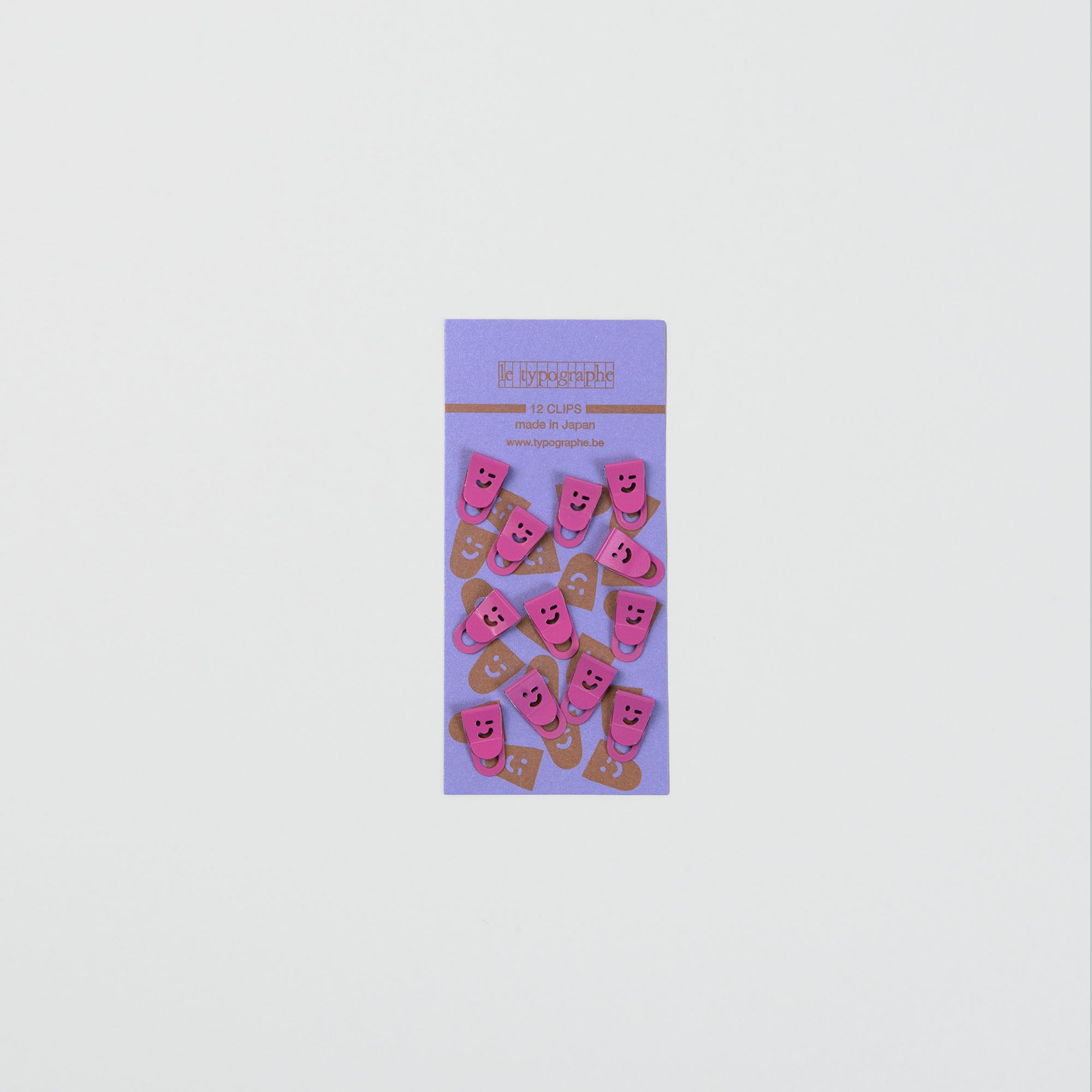 Eine Packung mit 12 Le Typographe Mini Clips Smiley in rosa und braun, auf einer lila Karte - ideal für die Organisation auf dem Schreibtisch.