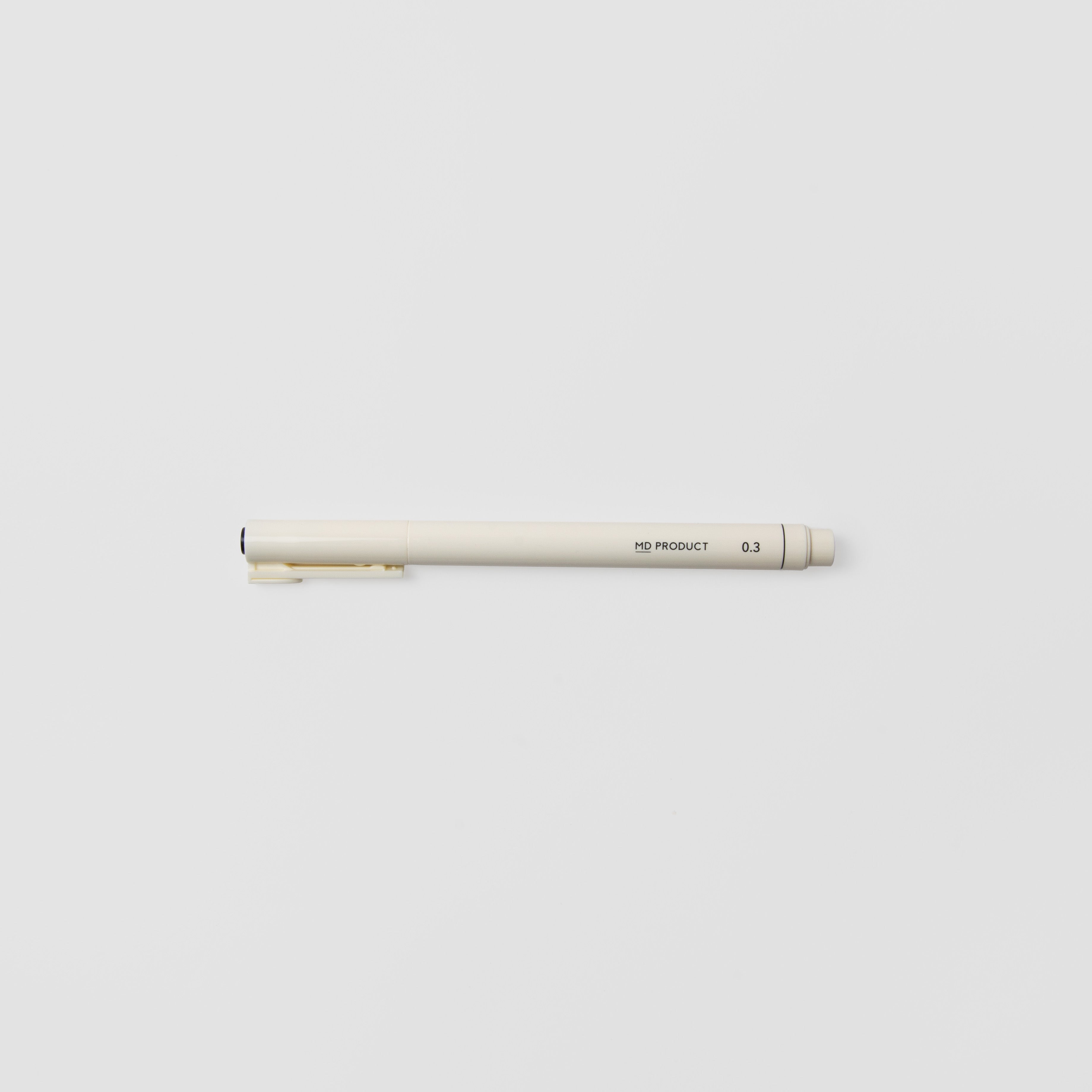 Ein Midori MD Drawing Pen 0.3mm mit beigem Korpus und feiner Spitze liegt waagerecht auf einem schlichten weißen Hintergrund. Dieser Midori-Stift verwendet wasserbasierte Pigmenttinte für präzise, glatte Linien.