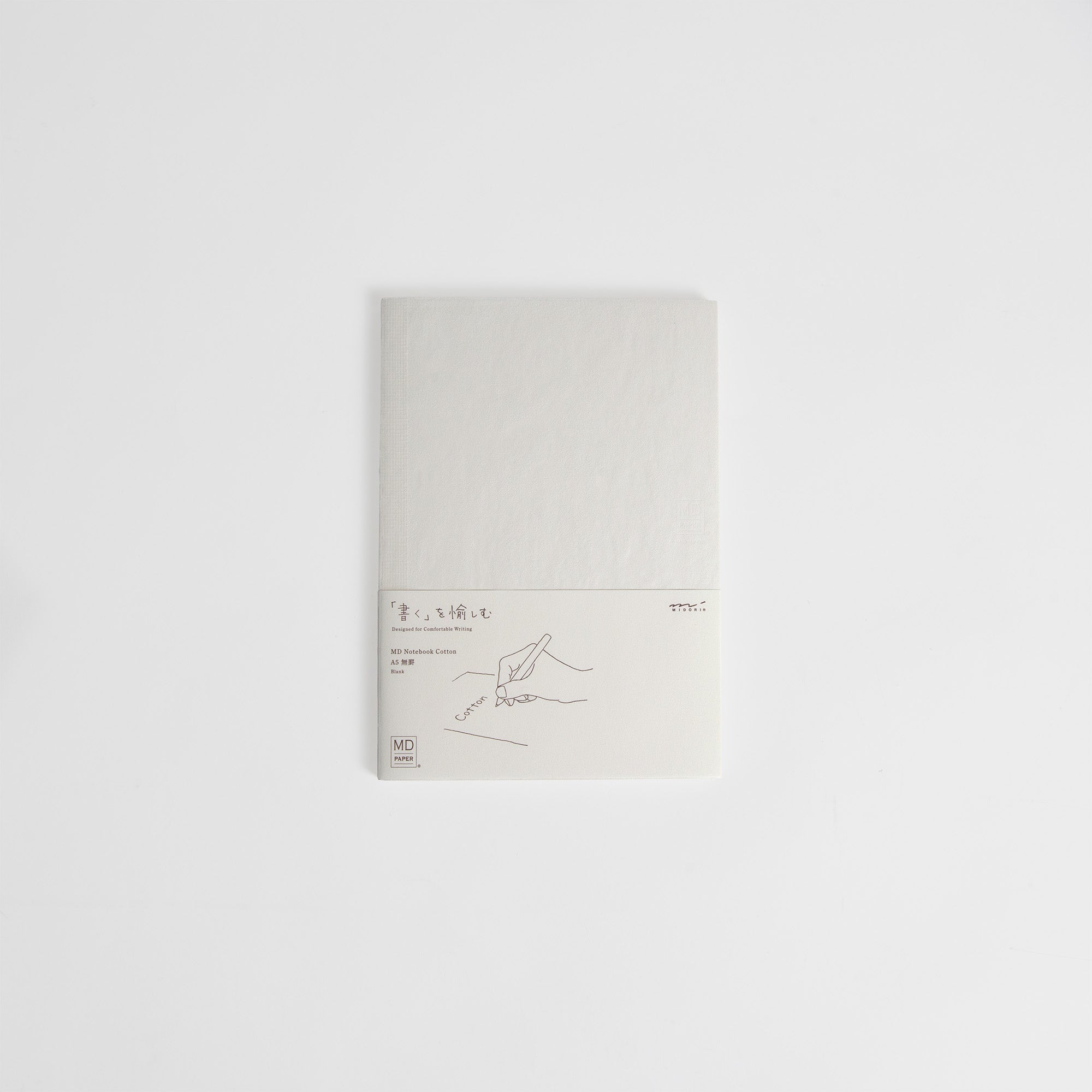 Das MD Notebook A5 Cotton von Midori hat einen schlichten weißen Einband, eine Fadenheftung, ein kleines Etikett mit japanischem Text, die Darstellung einer Handschrift und das MD Paper-Logo - alles elegant auf weißem Hintergrund.