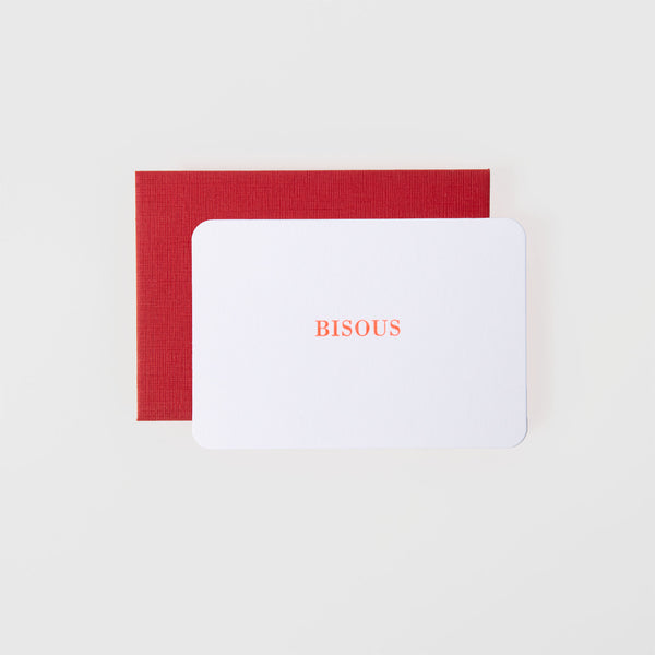 Die „Bisous – Minikarte“ von Le Typographe ist eine weiße Letterpress-Karte mit der Aufschrift „BISOUS“ in Rot und wird in einem roten Umschlag vor einem makellos weißen Hintergrund geliefert.