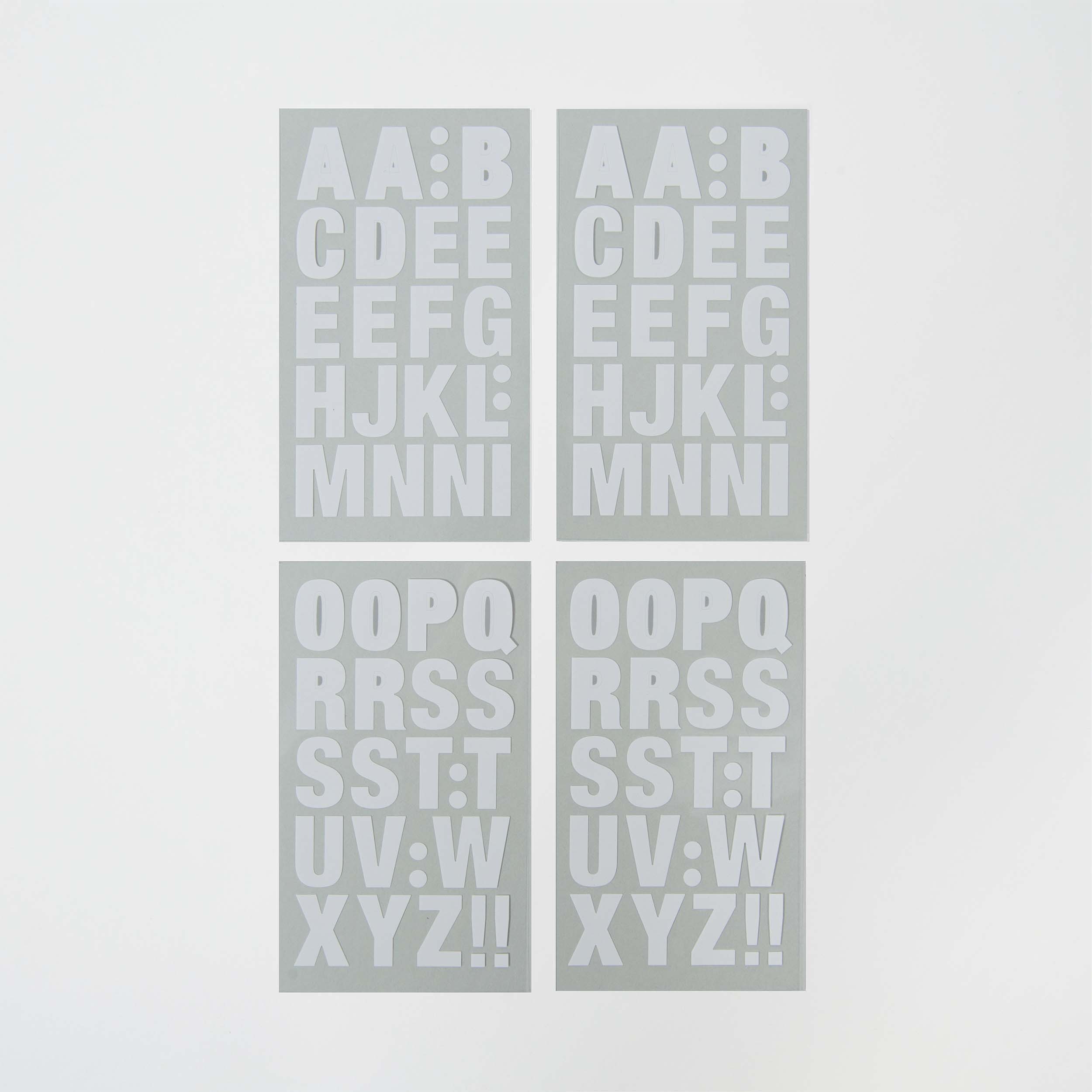 Die selbstklebenden Buchstaben von Paper Poetry bestehen aus vier grauen Karten mit weißen Großbuchstaben in einzigartigen Farben. Die Sätze „AAB CDEE FGHJ KLMM NNI“ und „OOP QRR SSTT UVW XYZ!!“ sind in zwei Reihen angeordnet und bieten eine kreative Beschriftungsmöglichkeit.