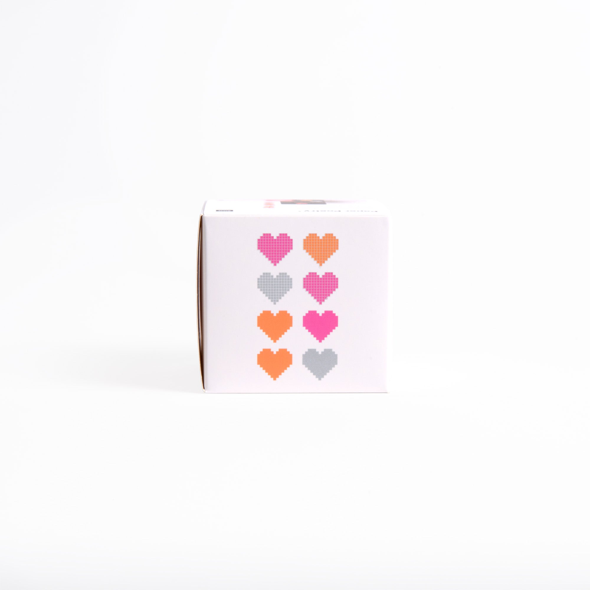 Eine weiße Schachtel mit sechs gepixelten Herzen in Rosa, Orange und Grau - wie die Paper Poetry Sticker Herzen "Pixel" von Paper Poetry -, die auf einer Seite aufgedruckt sind und vor einem schlichten weißen Hintergrund stehen.