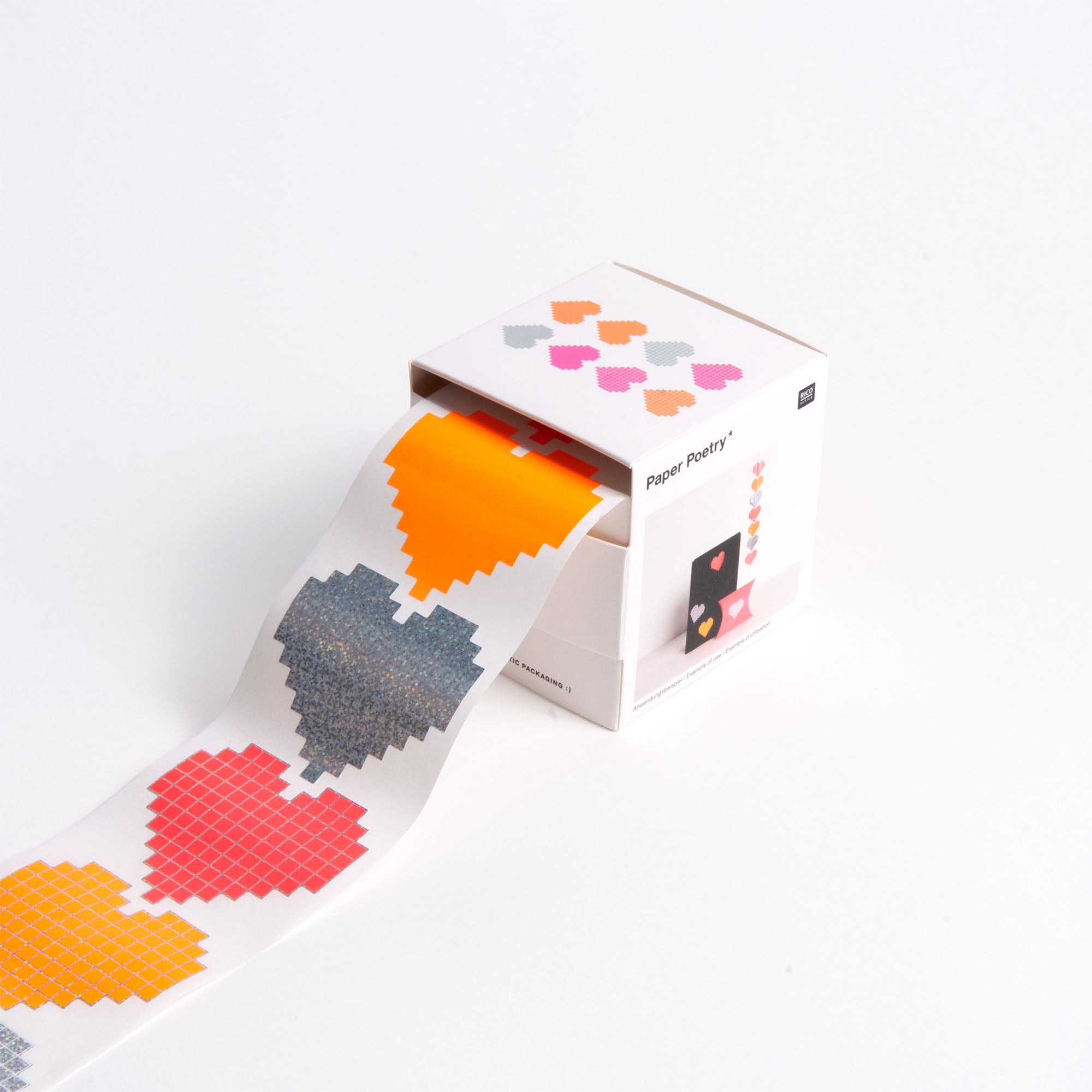 Eine Rolle Paper Poetry Sticker Herzen "Pixel" Dekoband mit orangefarbenen, grauen, gelben und roten gepixelten Herzen - passend zum Design der Box von Paper Poetry - wird teilweise abgerollt, um die lebendigen Herzmuster zu enthüllen.