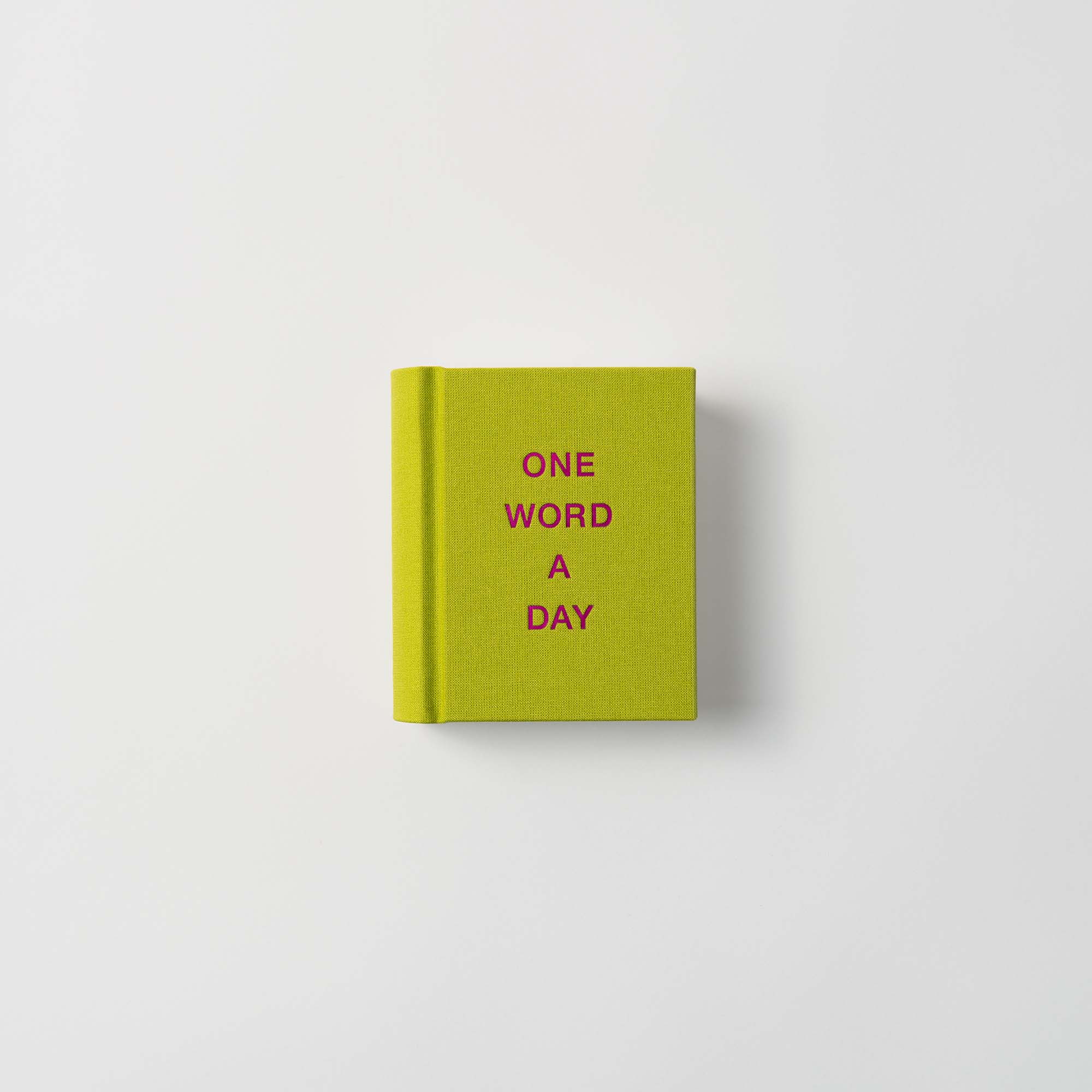 Der paperlux OWAD-Klassiker ist ein kleines, grünes Leinen-Hardcover-Mini-Notizbuch mit "ONE WORD A DAY" in rosa Großbuchstaben auf dem Einband, abgebildet auf weißem Hintergrund - ideal als Geschenk.