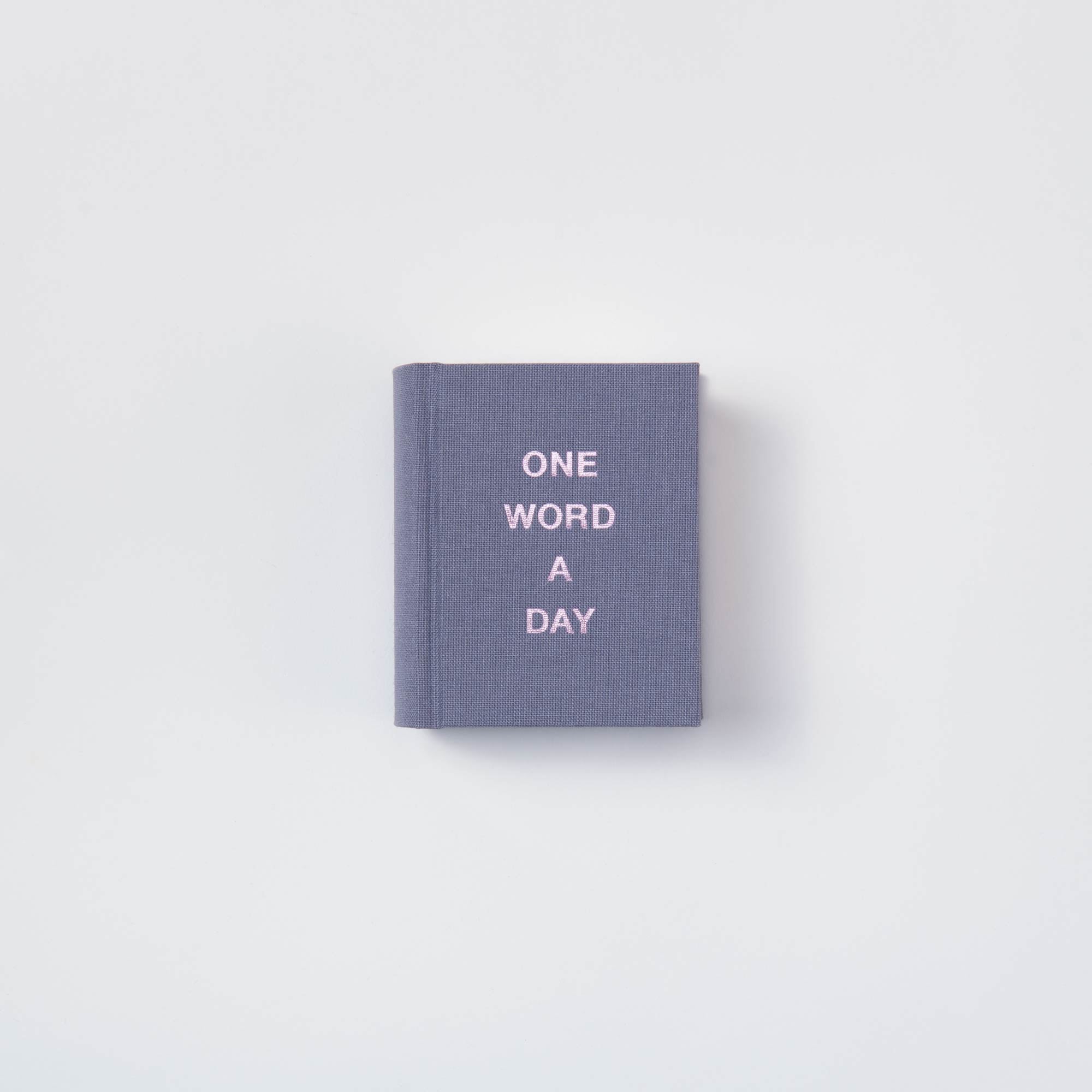 Das paperlux OWAD Elements ist ein kompaktes, graublaues Leinenbuch mit "ONE WORD A DAY" in Weiß auf dem Einband - ideal als Geschenk oder Mini-Tagebuch.