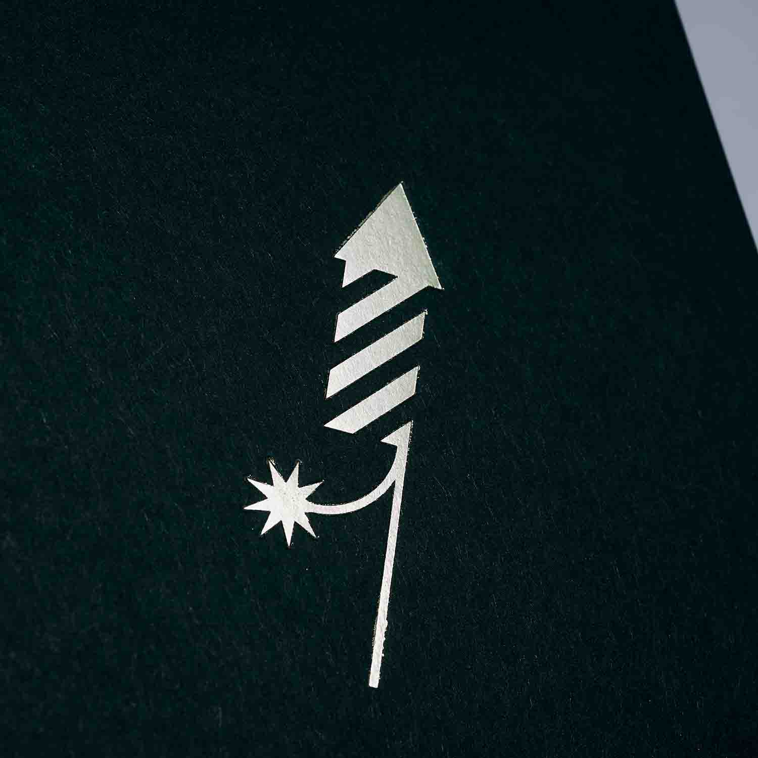 Ein minimalistisches goldenes Feuerwerk auf dunklem Hintergrund - ideal für das Weihnachtskarten 3er-Set von paperlux.store in Forest Green, Frost und Silver Dust (A6 Klappkarte).