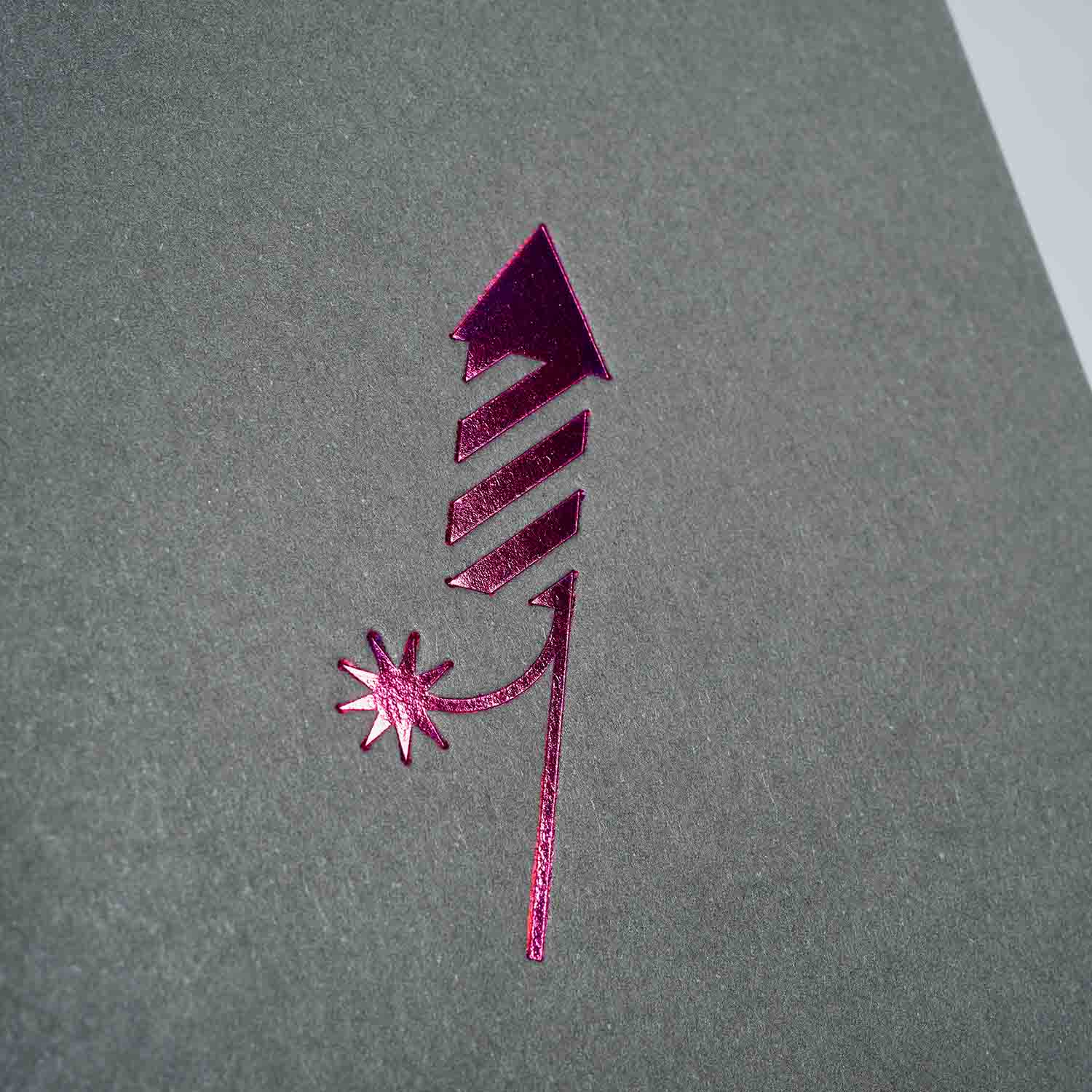 Eine metallisch glänzende, pinke Feuerwerksrakete mit Funken auf Grau - ideal für das Weihnachtskarten 3-er Set Chocolate, Shadow, Silver Dust von paperlux.store. Perfekt für festliche Grüße!.