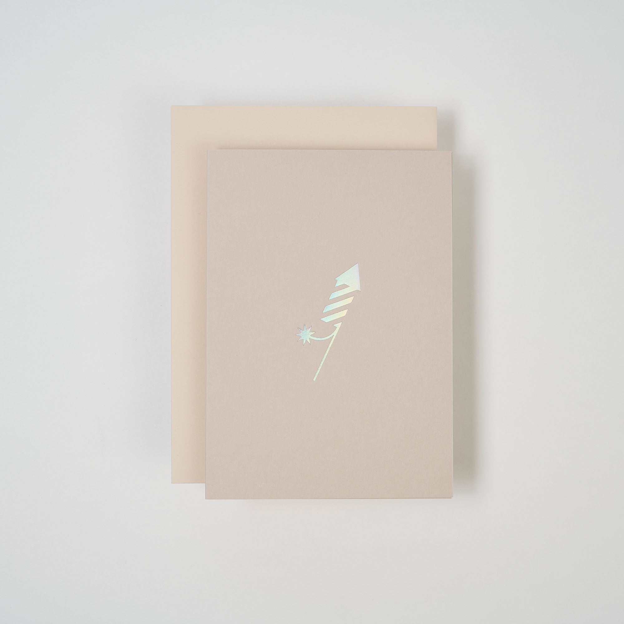 Die paperlux.store Karte Feuerwerk ist eine beige Klappkarte mit einem holografischen abstrakten Design, das an eine am Nachthimmel explodierende Feuerwerksrakete erinnert, gepaart mit einem helleren beigen Umschlag auf weißem Hintergrund.
