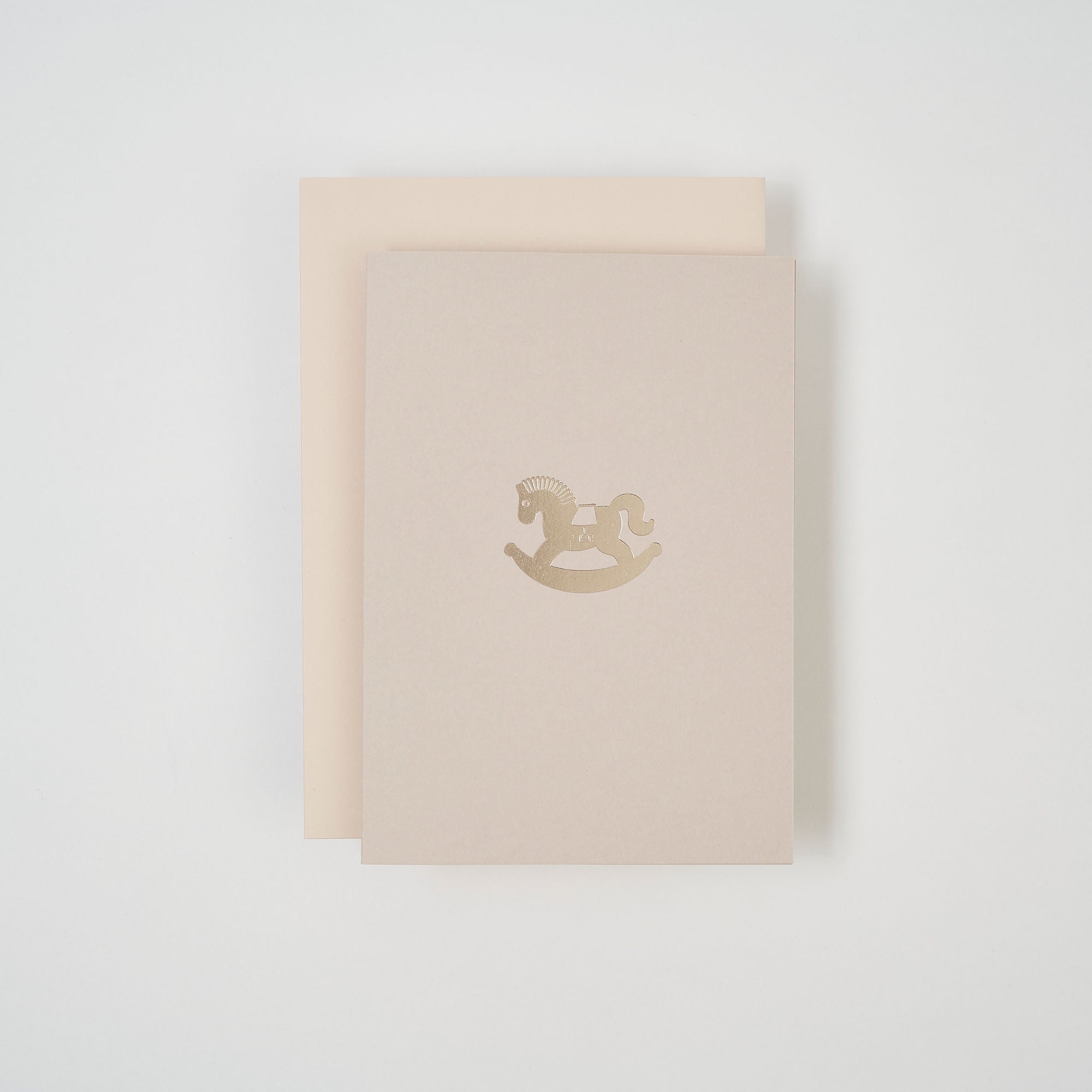Zwei hellbeige Schaukelpferd-Karten von paperlux.store befinden sich auf weißem Grund. Die obere Karte zeigt mittig ein kleines, goldenes Schaukelpferd-Emblem.