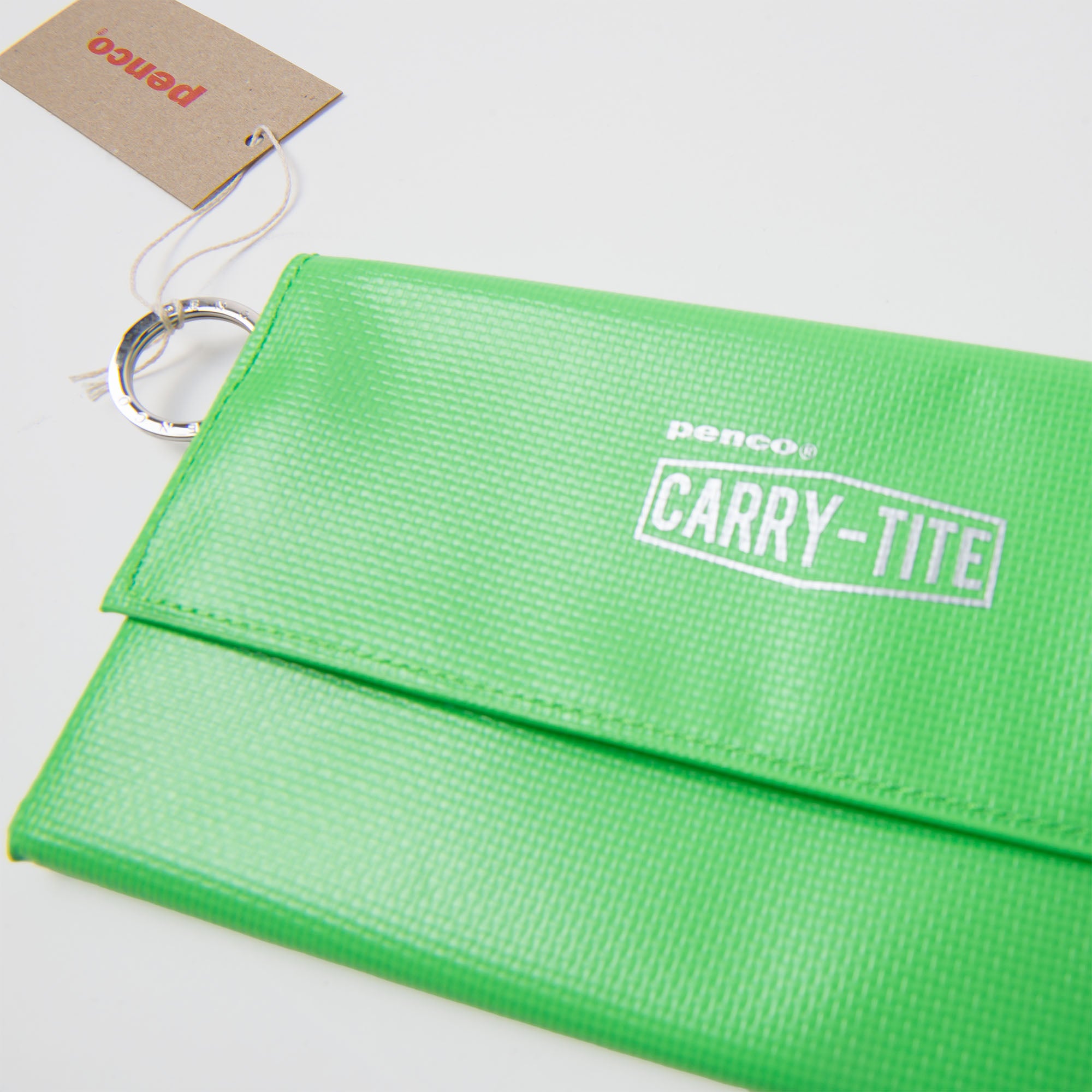 Ein leuchtend grünes Penco Carry Tite Tarp-Kugelschreiberetui aus wasserfester PVC-Plane mit silbernem Schlüsselring, braunem Anhänger, strukturierter Oberfläche und weißem Aufdruck vor weißem Hintergrund.