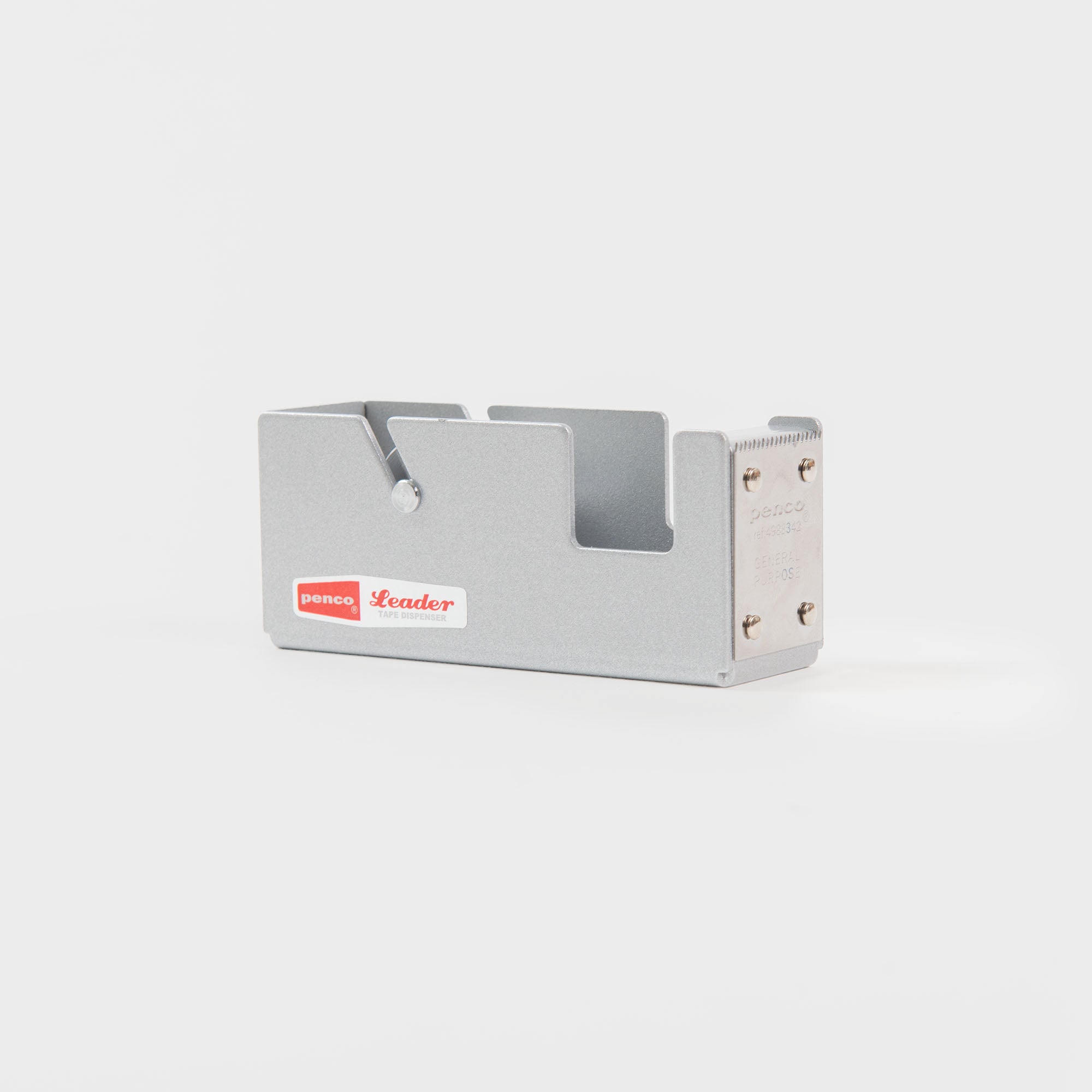 Der Penco Tape Dispenser S - Klebebandabroller zeichnet sich durch ein schlankes, rechteckiges Metalldesign mit einem rot-weißen Penco Leader-Etikett aus - ideal zum Einpacken von Geschenken - auf einem schlichten weißen Hintergrund.