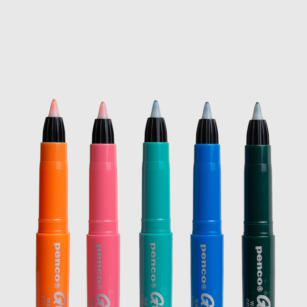 Fünf Penco Glider Colour Pen-Marker in den Farben Orange, Rosa, Blaugrün, Blau und Grün stehen aufrecht in einer Reihe vor einem schlichten weißen Hintergrund und heben so ihr Retro-Stift-Design und die geschmeidige Tinte auf Wasserbasis hervor.