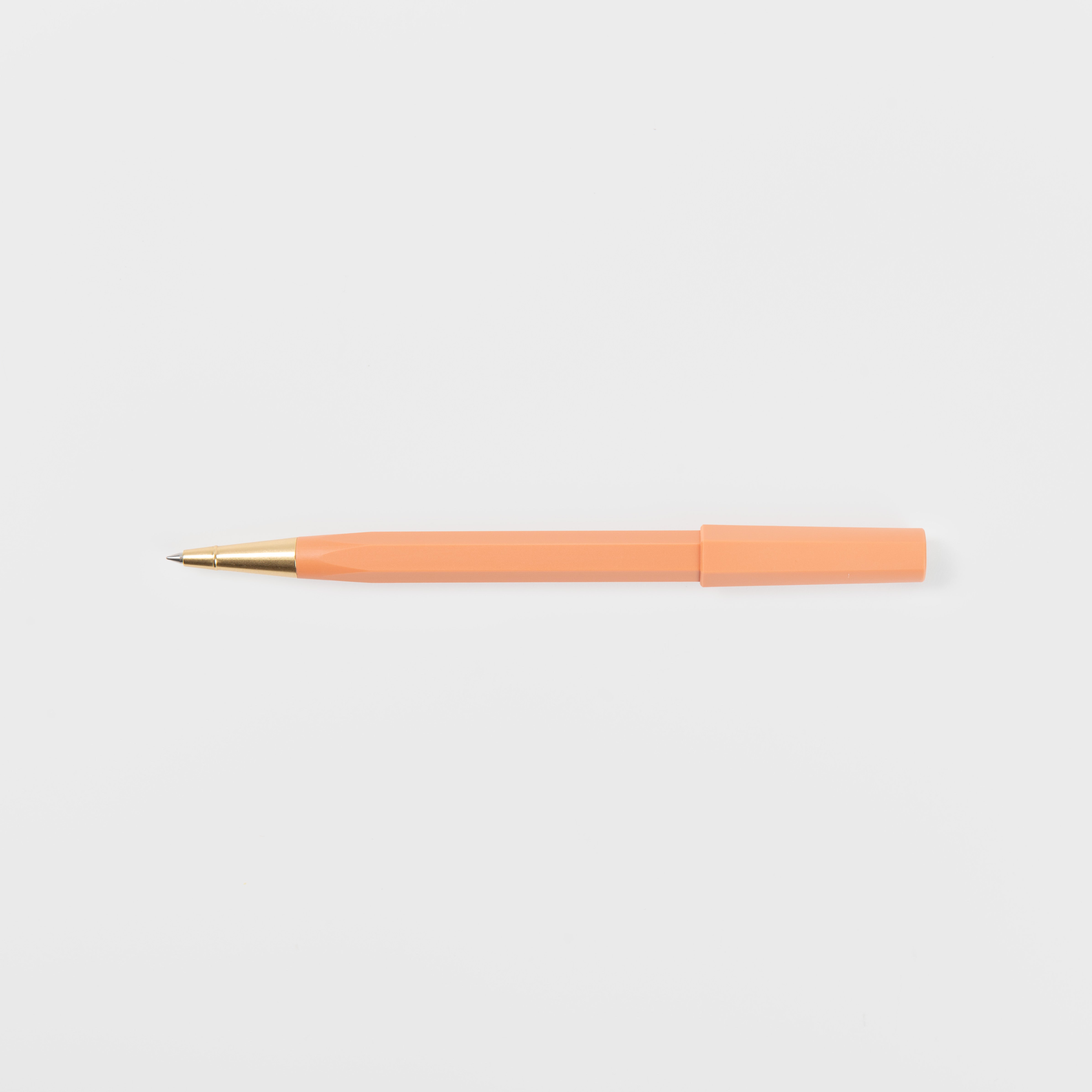 Ein orangefarbener Ystudio Rollerball - Ocean Edition Kugelschreiber mit goldener Spitze und orangefarbener Kappe, hergestellt aus recycelten Fischernetzen, liegt waagerecht auf einem schlichten weißen Hintergrund.